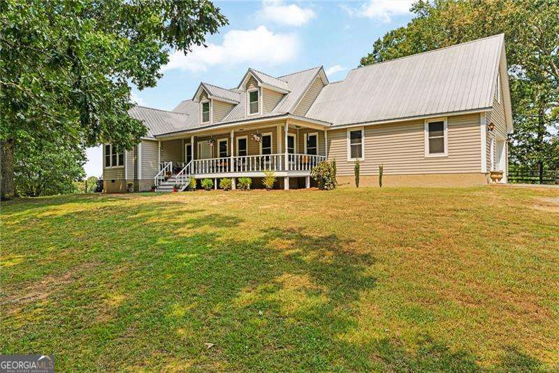 Welcome to a charming 9-acre farm offering the perfect blend of country living and modern convenience this property is ideal for those seeking a peaceful lifestyle surrounded by natural beauty. If you're looking for a small hobby farm, a homestead or a place to work and board your horses, this home has it all. As you enter through the gate you are greeted with large hardwood trees and rolling hills. Past the rocking chair front porch, you enter the home into an oversized living room with a floor to ceiling stone, wood burning fireplace perfect for cozy family nights. Open to the kitchen and breakfast bar making it ideal for entertaining. Gorgeous views surround the home with the newly replaced windows providing ample natural light. You'll have an oversized primary suite complete with a soaking tub and double vanities plus room for a sitting area to watch your animal's graze. Through the laundry room you can access a full studio apartment equipped with a full kitchen and bath. Outside you have an in-ground pool, a large covered gazebo, perfect for those summer cook outs or gathering for football season. At the back entrance of the property, you'll find raised garden beds with a semi enclosed greenhouse. A classic barn featuring 2 stalls, a tack room, and hay storage. Whether you dream of a working farm, a private homestead, or simply a charming place to call home, this property offers endless possibilities. With its acreage, functional barn, and versatile living spaces.