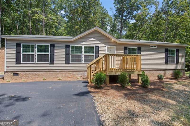 Welcome home! Ranch-style Home in a neighborhood with beautiful North Georgia Mountain Views. Looking to find the perfect affordable home in the North Georgia mountains? It's time to take a closer look at a quality manufactured option. This charming 4 bedroom, 2.5 bath in Clarkesville offers modern comfort, breathtaking scenery, and a peaceful, private setting - all at an unbeatable under $300k price point. It boasts a spacious, open floor plan perfect for entertaining with a large kitchen island and breakfast bar, as well as beautifully finished drywall, tile backsplashes, and a high pitched roof. This home sits on a permanent poured concrete foundation with real brick surround. Using the latest engineering techniques, this home offers all the longevity and safety of a traditionally built home at an accessible price point. The well appointed owner's suite is large and features dual vanities, a walk-in shower, and linen storage. The living area is open concept and includes an electric fireplace and room in the dining room for friends and family to gather. Enjoy the mountains on your own .8 acres of property with mature hardwoods, and plenty of space to expand. The lot has a very private feel with an asphalt driveway and three parking spaces. Clarkesville is a prime location in Northern Habersham. Just far enough out to maintain a small town atmosphere while still being close to a healthy, active community, great schools, and quality health care. This home is eligible for USDA 100% loans, FHA, VA, and conventional financing. Whether you're just starting out or ready to retire with financial peace of mind, this home is a great place to put down roots. Everything in this home is brand new and under warranty, ensuring your peace of mind. Don't miss this opportunity! Preferred lender program with lender credits and special financing available. Schedule your showing today. SELLER HAS A REAL ESTATE LICENSE. AGENT OWNED.