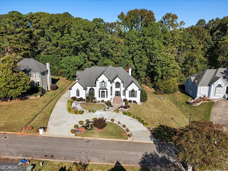 Grand family estate on a half-acre in Lawrenceville that blends gracious living "7-bedroom, 6.5-bathroom" European-style stucco home, spanning 5,912 sq ft. Inside, two-story foyer gleams with marble inlay, curved staircase, multiple living rooms, a private office, a large island kitchen with pantry, and flexible rooms that adapt to home-schooling, fitness, or guest suites. The home office offers French doors for additional privacy, beautiful built-ins & an expansive window overlooking the serene front yard. Expensive marble floors leads to formal dining/living rooms w/ intricated molding details on the ceiling, masonry fireplace, Extra space and bedroom in the finished basement opens possibilities for a media room, in-law suite, or teen retreat and endless entertainment. Access to the wraparound-covered deck, 3-car garage, long and circular driveway, Huge Backyard and professional landscaping.    Location is a big advantage: family-friendly parks, shopping, and dining are minutes away, and easy access to Hwy 316 and I-85 keeps commutes straightforward. **Optional HOA**