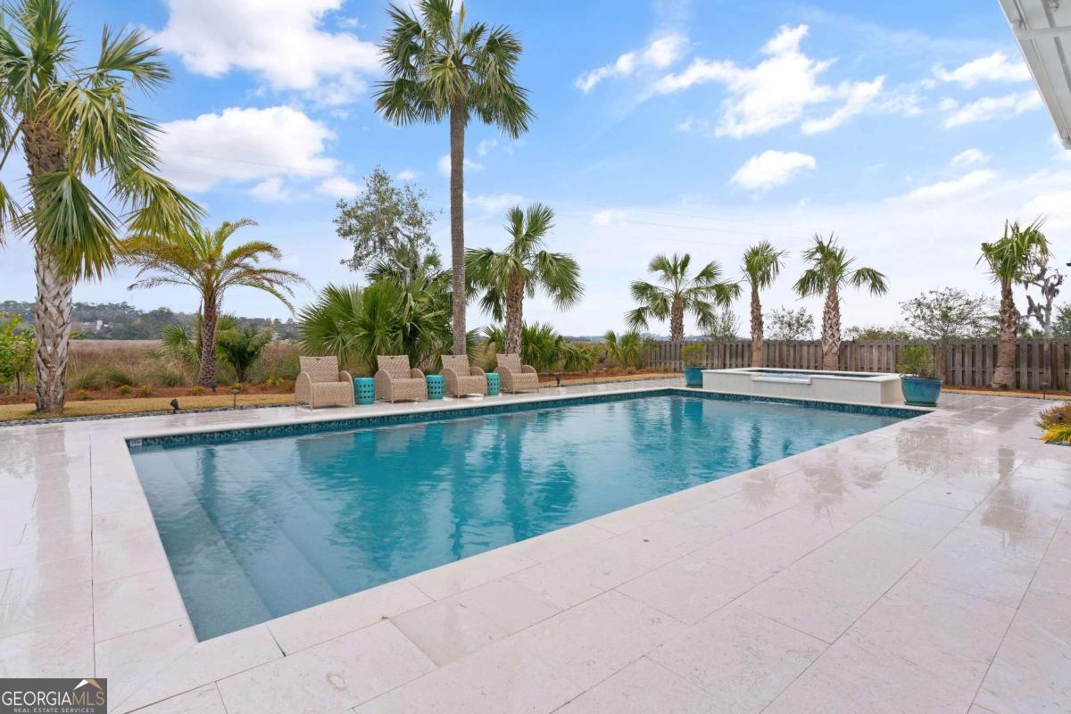 Enjoy the Low Country lifestyle in this 5 BR/5BA home overlooking the marsh in Hamilton Landing, a Sea Island developed subdivision which is one of St. Simons most desirable gated neighborhoods. This home has been well maintained and has many recent updates that you don't want to miss seeing. Along with the brand new salt water 18x36 swimming pool and spa, the exterior features cedar shake and tabby exterior, new roof, outdoor and indoor entertaining areas with beaufitul new 5th bathroom/pool bath that will give you the blues! For the interior, as soon as you enter the light filled foyer with its transoms, you will find the white oak, wide plank floors and picture frame wall moldings and gorgeous light fixtures. To the left and right of the foyer are a lovely dining room and a study/office/5th bedroom, which have picture windows of the oak filled neighborhood park. The foyer also overlooks a large living room with a media center and built-ins along one wall. French Doors open from the living room onto a spacious screened porch which provides a perfect spot for al fresco dining. The nearby Kitchen has a large quartz covered island with bar seating, stainless appliances including a gas range and double wall ovens and a built in desk. There is a large Butler's Pantry with additional storage, a food pantry, a sink and a washer/dryer area. A fireplace with gas logs surrounded by built-in bookcases is the focal point of the keeping room. It flows to a large outside deck with marsh views. The Primary bedroom is separated from the living room by a hall and an adjacent powder room with custom vanity. The Primary Bedroom has a tremendous view of the marsh through large windows. It has white oak floors, and it flows out to the screened porch through French doors. The primary bath has an L shaped double vanity with quartz countertops, a quartz surround tub and a separate shower. His and Her closets with built in shelving, and a laundry center in one closet complete the suite. The split plan has two guest bedrooms on the opposite side of the home. They both have the White Oak flooring and crown molding, walk in closets with shelving and they share a Jack/Jill bath each with their own vanity rooms separated by pocket doors. One of the bedrooms overlooks the park, and the other overlooks the marsh. There is another marsh front guest suite upstairs that has a recently updated en suite bath, a shiplap accent wall and a sizable sitting area. There is an oversized two car garage with an adjacent work shop area with space for sports gear and lots of storage on the ground level. There is also a downstairs bonus room that can be used as an exercise/game/media room and a brand new exquisite bath. Hamilton Landing has its own park, dock and boat ramp, paved bike/walking paths throughout making it a favorite neighborhood for the island. It is very convenient to Frederica Academy, walking trails and all of the fun of south end St. Simons Island. It is also very convenient to the Torras causeway. Sea Island Club application rights are also available. Come experience the breezes through the live oaks, kayak out of the boat landing and relax!