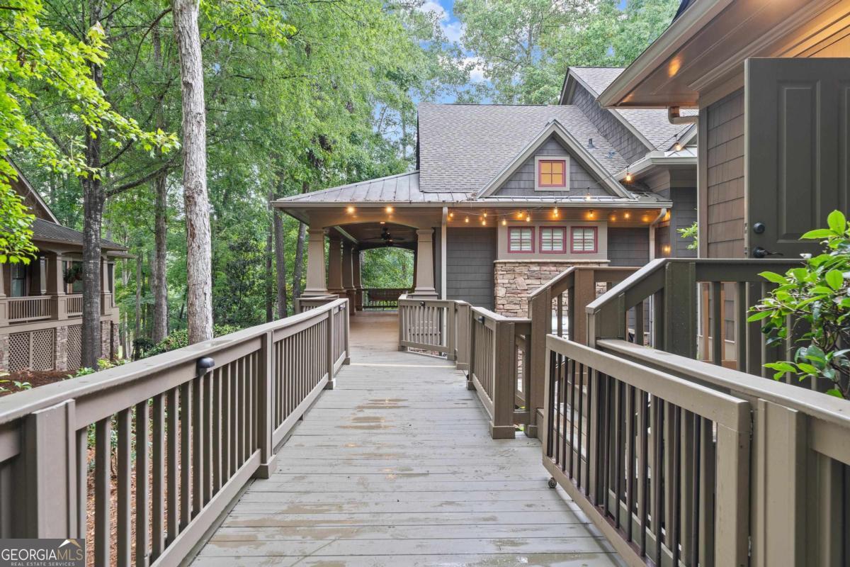 Don't miss this one of kind National Village II Townhome in Reynolds Lake Oconee. This recently renovated 3 Bedroom, 4 Full & 1 Half Bath Home is situated on the 7th Green of The National Golf Course and the views from throughout both levels of the home are amazing. Inside, the typical National Village floor plan has been improved to now included on the main level an amazing Dining Room with floor to ceiling windows and 2 living areas, each with their own fireplace. In the Terrace Level, you still have a cozy Family Room with wonderful built-ins but an additional "Sleeping Room" has been added along with a full bath to create even more space for visiting family in friends. When you add in an amazing outdoor patio with Fire Pit & Outdoor Kitchen, this great property must be seen in person to truly be appreciated. Seller is making a Club Membership available.
