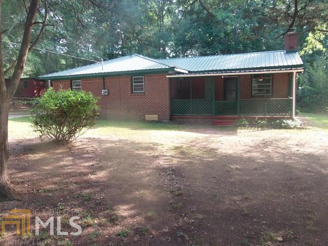 Easy to maintain brick ranch with attractive hunter green tin roof! Property located on a mature two acres. Large detached two car garage, plus additional storage shed. Living room features brick fireplace, hardwoods in dining area, and breakfast bar in kitchen. Formal dining room with original wood paneling. First Time Buyers, complete the Ready Buyer homeownership course online. Attach certificate to offer and request up to 3% closing cost assistance. Ask me for details. Restrictions apply. Any realty transfer taxes due will be the sole responsibility of purchaser.