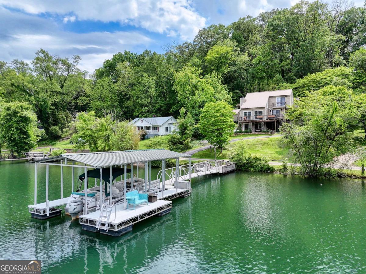 Lakefront Living at Its Finest! Welcome to this beautiful 3-bedroom, 3-bath lakefront home on Lake Chatuge with Gorgeous Mountain views- perfect for year-round living or a fantastic short-term rental opportunity. This Lakefront home is designed for entertaining. The open-concept floor plan seamlessly connects the living room, dining area, and kitchen, all filled with natural light from the expansive windows. The real wood-burning fireplace adds cozy charm to the spacious living room, while the fully finished basement offers even more living space. Step outside to your private covered dock with a single boat slip, or launch directly from your private on-site concrete boat ramp. With a one-car garage, paved driveway, plenty of storage and minimal restrictions, this property offers flexibility, comfort, and endless lakefront enjoyment. Most Furnishings will Convey! Call me today!
