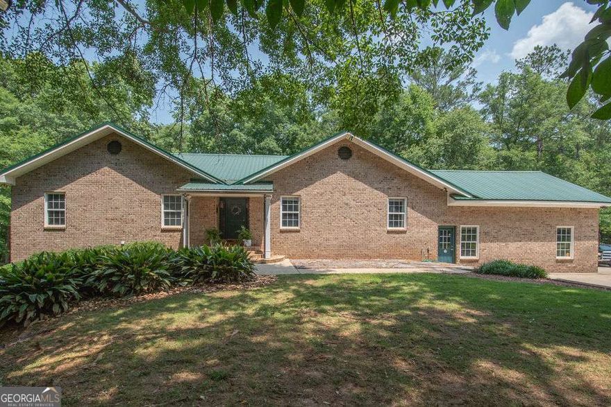 Welcome to your dream retreat!  Nestles on a private wooded lot in Williamson, GA, this residence offers luxury living spanning a generous 5,152 square feet.  The home features five inviting bedrooms and three and a half baths, making it an ideal haven for a large family or hosting guests.  The heart of this home is its magnificent European-style kitchen, with more cabinet space than one can imagine plus a double oven and Sub-Zero refrigerator!  Even the downstairs kitchen surpasses anyone's expectations with it's endless granite counter space, catering to your culinary adventures and organizational dreams including a double oven.  This property is a true sanctuary for those who value privacy and the great outdoors.  The expansive grounds provide the perfect backdrop for relaxation and exploration alike. Included on the property is an amazing 36'x 82'workshop complete with four oversized automatic garage doors - a dream for hobbyists and entrepreneurs.  30 amp & 50 amp hookup for campers.   Nature enthusiasts will be enchanted by the beautiful, large stream that weaves through the property, offering peaceful walks and tranquil moments. The thoughtful layout supports a two-family arrangement, providing abundant space and privacy for multi-generational living or accommodating guests with ease. Constructed with undeniable quality, this home isn't just built-it's meticulously crafted with an eye for detail that ensures lasting beauty and comfort. The community provides convenient access to essentials-CrossPointe Christian Academy for educational pursuits, Freshway Market for grocery shopping, and Concord City Park for recreational activities. Nearby dining and event venues like Barnstormer's Grill and Event Center make social outings effortless. If a mix of spacious elegance, thoughtful amenities, and a touch of natural splendor is what you seek, discover how this exquisite home might just be your next chapter.