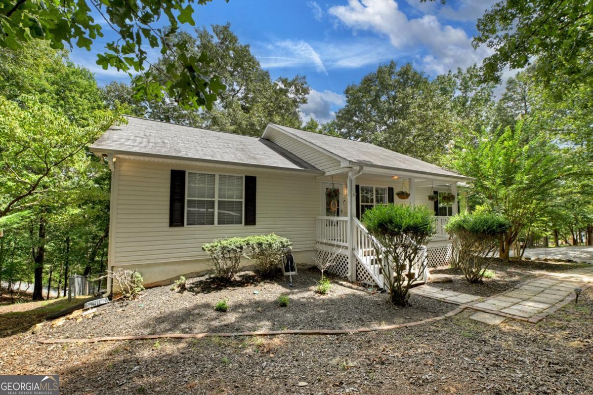 Step into comfort and style with this beautifully updated 3-bedroom, 3-bath ranch-plus an additional finished room and one full bath on the terrace level. This home offers everything from a welcoming front porch to a spacious fenced backyard. Inside, enjoy a large open floor plan with gleaming hardwood floors and a stunning rock gas-log fireplace. The kitchen is a chef's dream, featuring new quartz countertops, stainless steel appliances, a tile backsplash, oak cabinets, a large island, a pantry, and a generous dining area. All three bedrooms are conveniently located on the main level, including a spacious master suite with his-and-her closets, new carpet, and a luxurious bath with a marble double vanity and tile flooring. A second updated main-level bath features marble counters and tile floors, and the nearby laundry room adds convenience. Step out from the dining area to a large screened-in porch overlooking the backyard-perfect for relaxing or entertaining. Downstairs, the terrace level offers even more flexible living space with a finished bonus room and a full bath with LVP flooring. Additional perks include a 2019 roof, a Generac whole-house generator, an insulated storage building with electricity, and an extra-deep 2-car garage for added storage. This home is located in a gated community with lots of amenities that include an indoor pool, fitness center, river park with pavilion and basketball court and river access, game room, 2 outdoor pools, tennis courts, pickle ball court, putt putt golf and more.