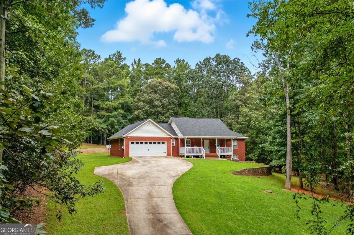 Every detail has been considered in this 4-sided brick home, making it as solid as it is beautiful. Recent upgrades include a new roof (2020), covered gutters, a brand new back deck (2024), freshly painted and reinforced front porch, and a new garage door (2025). Inside, you'll love the warmth of real hardwood floors, fresh interior paint, updated lighting and fixtures throughout, and a completely remodeled primary bath. The spacious living area with a gas fireplace flows into the kitchen and dining, creating the perfect gathering space. Outside you can enjoy quiet mornings or evening sunsets on the rocking chair front porch or new back deck overlooking the acre lot. With all the major improvements already completed, this home offers buyers peace of mind for years to come. Conveniently located near schools, shopping, and I-20, this move-in ready property is a rare find in Winston. Note: Listing Agent is related to the seller.