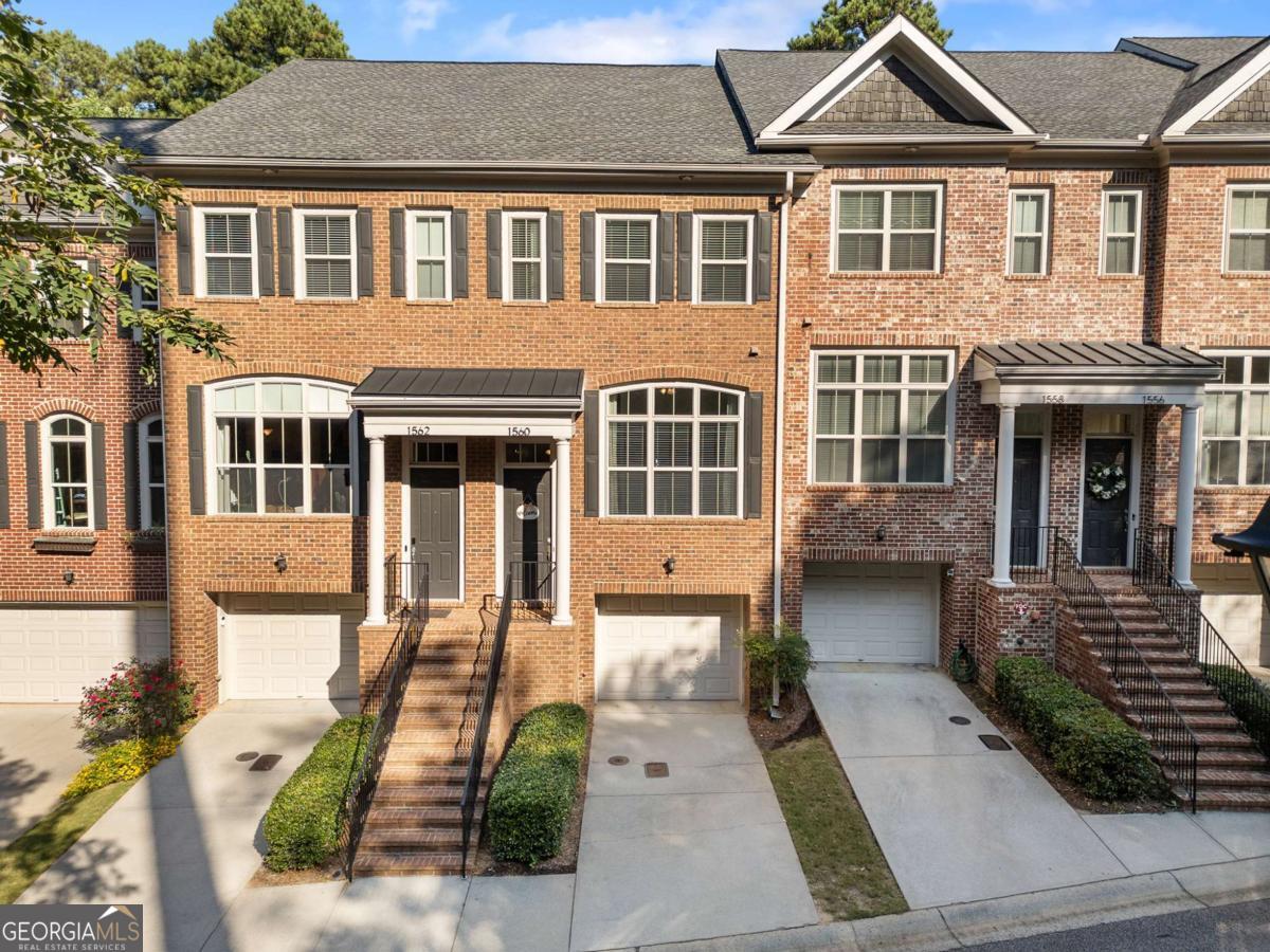 Welcome to 1560 Mosaic Way in Smyrna! This beautifully updated townhome is located in the highly sought-after Mosaic at Vinings community and offers 3 bedrooms, 3.5 bathrooms, and a versatile floor plan designed for modern living. Step inside to find a bright, open main level featuring a spacious living area and separate dining room, perfect for entertaining or relaxing. The kitchen shines with white cabinetry, updated light fixtures, and gorgeous refinished hardwood floors, all set against freshly repainted, neutral-toned interiors that create a warm and inviting feel. The lower level includes a private office or bedroom with newer luxury vinyl flooring, a full bath, and a mounted TV that stays with the home-making it an ideal guest suite or work-from-home space. Upstairs, generously sized bedrooms provide comfort and privacy, while the primary suite offers a true retreat. Additional highlights include: One of two HVAC units has been replaced in the past five years as well as a double tandem garage with ample storage and workspace with shelving and workbench included with the home. Behind the gated entrance, residents enjoy a sparkling community pool, playground, and green spaces-perfect for relaxation and recreation. All this just minutes to Smyrna Market Village, Rev Coffee, Truist Park, The Battery, and major highways for an easy commute. Don't miss the chance to call 1560 Mosaic Way your new home!