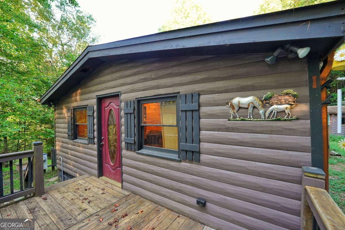 Cabin-Style Privacy in the Mountains! Nestled on 1.92 acres in the heart of Cherry Log, this 4-bedroom, 2-bath manufactured home with log siding offers the perfect blend of rustic charm and modern updates. Recently remodeled with warm wood finishes, new flooring, a cozy stone fireplace, and updated kitchen features, the home is ready for you to add the final finishing touches and make it truly your own. Set high on a hill surrounded by trees, the property offers privacy, acreage, and no HOA restrictions-making it ideal as a full-time residence, a family vacation getaway, or a short-term rental investment. With multiple decks for outdoor living, there's plenty of space to enjoy the peaceful mountain setting. Outdoor enthusiasts will love the location-just minutes from the Benton MacKaye Trail and Fall Branch Falls Waterfall, and less than 30 minutes to Lake Blue Ridge for boating, fishing, and endless recreation. Additional features include an individual well, ample parking, and four spacious bedrooms for guests or family. Being sold as-is, this home is a unique opportunity to complete the last details and create your dream retreat in the mountains.