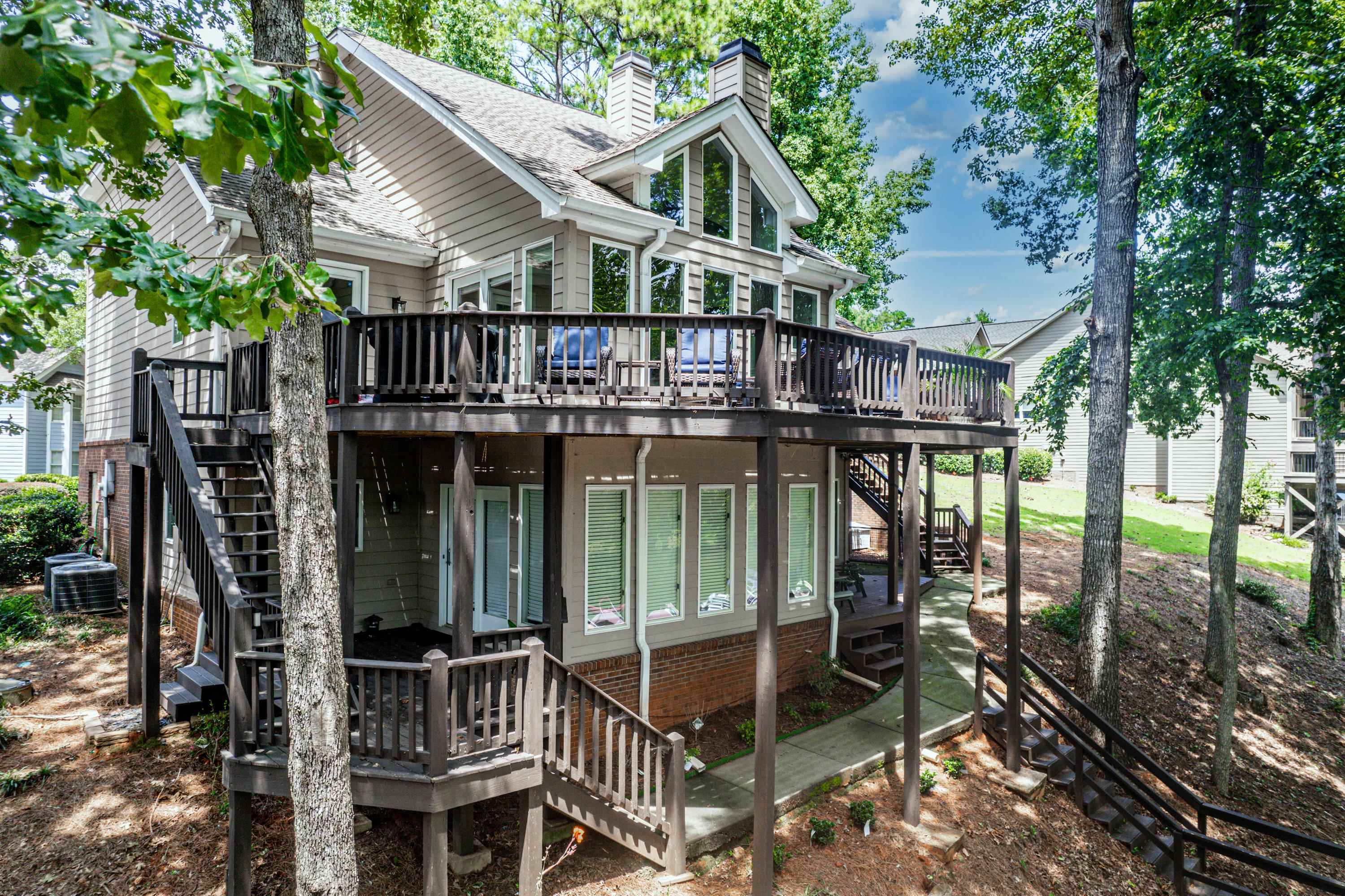 These "one of a kind" townhomes ON LAKE OCONEE always sell fast! This cute duplex/townhome features 3 separate bedrooms (one on each level) with 3 full baths, new paint, new carpet, and new LVT flooring on the lake-terrace level. This sweet, gated "secret neighborhood" is located in the heart of Lake Oconee convenient to Publix, restaurants, St. Mary's Hospital, banks, shopping, I-20 and more! There's a private pool that is just steps away from every home in Vintage Club.. And the most amazing addition to this beautiful home is the fact that it has 2 private/assigned boat slips on Lake Oconee. The back porch gives you a feeling that you're "home at the lake", enjoying the sunshine,.... nestled within the trees with great lake views all over! Each private bedroom is on it's own floor so it's fabulous for family or guests. It is also located in the sought after "Lake Oconee Academy" school zone. It will not last long at this amazing price.