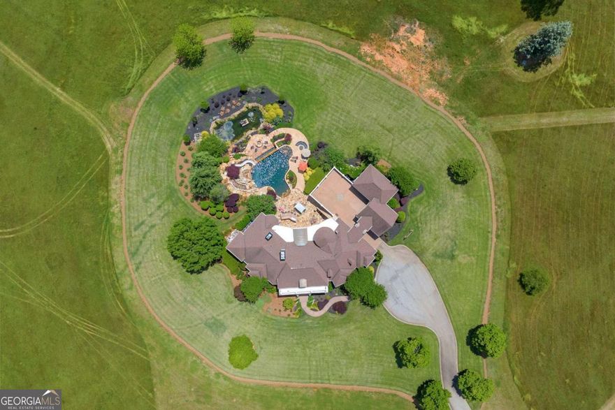 Welcome to "Rolling Hills Farm"  This estate home and 216 acres borders the Apalachee River and is located less than 20 minutes from Athens, Ga.  As you enter the property through the gated entrance and enjoy a tree line driveway, you soon arrive at the porte cochere of your new home.  The double front doors welcome you into the marble tile entrance with an abundance of natural light. To your right and left you will find a formal dining room and sitting parlor. You then enter into the formal living room with stone fireplace and custom built in bookcases. Directly off of the living room there is an expansive veranda that overlooks the outdoor kitchen, resort style pool (with slide), koi pond with water feature and a breathtaking view of your property. There is a large chef's kitchen with luxury stainless steel appliances, granite countertops and breakfast nook with rounded windows. On the main level of the home there are four bedrooms, each with a private full bathroom.   Also on the main level is the executive wood panel office with fireplace and the owners suite. Large windows overlooking your acreage with access to the porch accompany your owners suite as well as oversized bathroom featuring his and hers sinks, tiled rain-head shower, soaking tub and custom closet. As you ascend the stairs from the main level, you will find a space that is ideal for a teen or in-law suite, with large bedroom/sitting area space, multiple closets and ensuite. This level features a catwalk that attaches to the garage for ease of access/game room.   On the terrace level, more space abounds. Full kitchen with upgraded appliances and granite countertops along with two rooms functioning as "bedrooms" with closets, zero entry bathroom and office. There is also a home gym with a resort sized steam room and sauna. The backyard is perfect for entertaining many guests as you have multiple seating areas with an outdoor grill kitchen, pool seating, koi pond and water feature. The estate home features a newer 50 year roof on the main house. This property has 216 acres, so the home itself is only one of the many features! Ideal to be purchased and turned in to a family style compound. There is one lake (with patio/deck/entertaining area) and two ponds for quiet enjoyment. You will also find a horse stable ( room for no more than 3 horses) , outdoor barracks, and small structure for land maintenance equipment.   A brand new 4,000 sq ft steel framed partially enclosed barn will house all of your farm equipment and recreational vehicles.  "Rolling Hills Farm" is a  true sportsman's paradise abounding with wildlife; excellent fishing opportunities and hunting for deer, turkey, ducks and hogs. Whether a family compound or private oasis is what you're searching for, look no further than 3881 Sims Bridge. Please contact Nathan today to schedule your detailed private showing of this amazing estate.