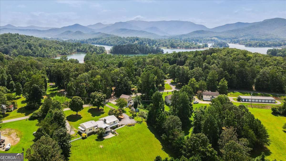 Nestled on 2.12 serene acres in the heart of the North Georgia Mountains, this 5,334 sq. ft. property offers the perfect blend of privacy, natural beauty, and flexible living options. Just minutes from Lake Chatuge, Brasstown Bald, Young Harris College, and the Georgia Mountain Fairgrounds, you'll be surrounded by opportunities for boating, hiking, fishing, and exploring the scenic Appalachian Mountains. The charming Bavarian-style village of Helen, GA, is only a 30-minute scenic drive away for even more adventure. The main home features 4 bedrooms, 3 baths, a dry sauna, and a hot tub with stunning year-round mountain views. Connected to the main home is a 1-bedroom, 1-bath apartment with its own full kitchen and laundry area, currently leased for $1,175 per month. The apartment can easily be converted back to flow seamlessly into the main house by reopening the walled-in doorway perfect for creating an additional private primary suite on the main level, an extra kitchen for entertaining, or even more space for family gatherings. A detached 2-bedroom, 2.5-bath guest house with a full kitchen and laundry offers even more flexibility, currently leased at $1,500 per month. Whether you keep these spaces as income-producing rentals or host extended family and friends, the possibilities are endless. Over $300k in renovations have transformed this property inside and out. The main home, guest house, and apartment received extensive updates including new roofs, plumbing, electrical upgrades, flooring, fixtures, windows, and fresh paint throughout. Kitchens and baths were modernized with new vanities, appliances, and granite countertops, while outdoor improvements include new balconies, retaining walls, fencing, landscaping, and French drains for enhanced curb appeal and functionality. With a total of 7 bedrooms and 6.5 baths across three unique living spaces, this property is ideal for a full-time residence, a multi-generational retreat, or a private compound with built-in income potential all set against the stunning backdrop of North Georgia's mountain landscape.