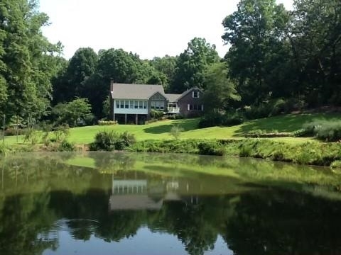 PRIVATE OASIS ON 10.3 ACRES. This is an amazing Retreat with a Fountain Fully Stocked Pond/ Garden areas and amazing Landscaping. All the Privacy you could want. Charming Very Spacious Craftsman Home with Porches all around. This home has Solid Oak Hardwood Floors. with a two story Entrance Way. Amazing Great Room with Tall Stacked Stone Fireplace and Custom Built in Bookshelves. So spacious and inviting. Great room area leads to Sunroom with Clear Pane Windows overlooking Incredible Garden areas and Pond. OPEN CONCEPT KITCHEN AREA with oversized Custom Cabinets and Built In floor to ceiling PANTRY SPACES. Very Impressive STAINLESS APPLIANCE PACKAGE THAT INCLUDES DOUBLE OVEN. Oversized Thermal Refrigerator. Huge Kitchen Island with GRANITE COUNTERTOPS. All bedrooms are Spacious with private bathroom suites. Master Bedroom is Generous with lots of Walk in Closet Space and Private Deck. Master Bath has Beautiful Tile Work/ Double Vanities and Granite Countertops. Separate Shower and Oversized Jacuzzi Tub. Upstairs area has a FULL SIZED LOFT Flk about OR OFFICE SPACE OR FAMILY ROOM AREA. Plus bedrooms FULL FINISHED BASESMENT WITH FIREPLACE. Downstairs basement has SECOND KITCHEN AND ADDITIONAL GREAT ROOM. Bedroom Suite has spacious bath and 2nd laundry. OUTSIDE PATIO AND GARDEN SPOT FROM TERRACE LEVEL.. Talk about upkeep- this home has New Roofing and 4 HVAC units. 2 CAR GARAGE PLUS SECOND TWO CAR GARAGE! The home caters to Garden areas with lots of Hardwoods and Fruit and Flowering Trees. Plus there is a Greenhouse! This home and grounds are so inviting and welcoming. Enjoy Gorgeous Garden Areas Overlooking The Pond from any of the Private Patios. All this plus Great Cumming Schools and Convenience. COME SEE- YOU'LL BE AMAZED.