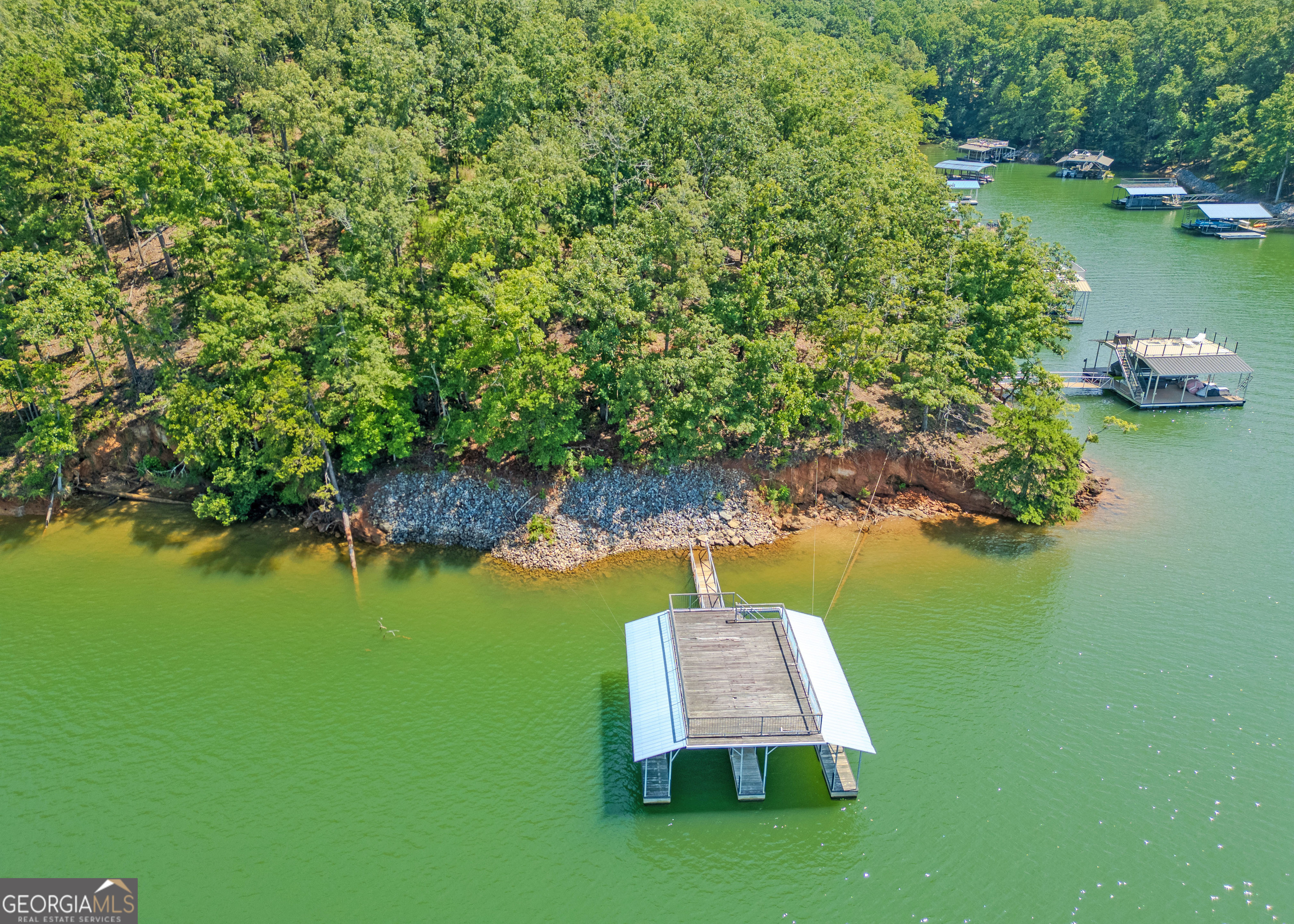 Discover the rare opportunity to own a prime residential lot in the Chestatee school district on the shores of Lake Lanier. This undeveloped lot located on a point with 95 feet of Corp Lin and has over 35 feet of water depth and offers the perfect blank canvas to build your custom dream home! This lot is nestled on a quiet cul-de-sac in a desirable community, and includes a double-decker 2-slip boat dock that is ideal for enjoying lake activities. Bring your plans and enjoy living the lake life!