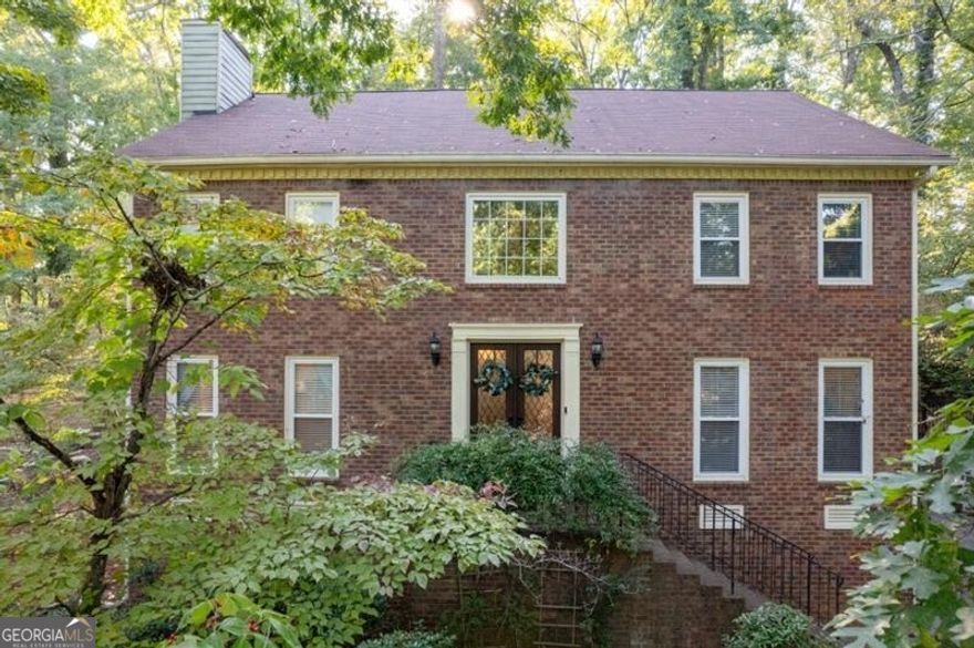 Welcome to this classic and beautifully updated brick home located in the highly sought-after swim and tennis community of Lansdowne. This beautiful property offers a perfect blend of modern updates and timeless charm, ideal for comfortable living and entertaining. Upon entering, you are greeted by a welcoming foyer that opens to a bright living room featuring double French doors and an elegant dining room. The spacious family room boasts a cozy fireplace, creating a warm and inviting atmosphere. The adjacent kitchen is a chef's delight, featuring white cabinetry, stone countertops with a stylish tile backsplash, and stainless steel appliances including a gas range. A convenient computer nook/desk and a sunlit breakfast area complete this functional space. The kitchen opens to a charming sunroom, providing seamless access to the outdoors. Step outside to enjoy the expansive deck, complete with a swim spa lap pool/hot tub and patio area, overlooking the private wooded backyard perfect for outdoor gatherings and relaxation.The upper level features an oversized owner's suite with a tray ceiling and a luxurious updated bath. The ensuite includes a vaulted ceiling with a skylight, a double vanity, a separate shower, and a freestanding soaking tub. A large custom walk-in closet provides ample storage. Three additional secondary bedrooms share a well-appointed hall bath. The laundry room rounds out the upper level. The finished terrace level offers exceptional versatility, featuring a kitchen, bedroom, full bath, a second laundry area, and a separate entrance ideal for an in-law suite or guest accommodations. Located in a vibrant neighborhood with outstanding amenities including a clubhouse, pool, tennis courts, and a serene lake, this home is perfectly situated near shopping, dining, parks, and major highways (I-75 and I-575). It is also within the highly acclaimed East Cobb School District, offering top-rated educational opportunities. Don't miss the opportunity to make this exceptional home yours!