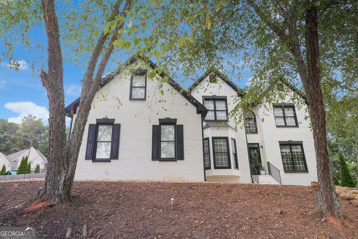 A Stunning HGTV Worthy Home with Luxurious Southern Charm Has Come to Marietta Located in the Due West School District! This stunning Marietta residence has been thoughtfully transformed from top to bottom, completing the amazing renovations and upgrades while blending modern touches with timeless character. From the moment you step through the custom double front doors, you're welcomed into bright, airy spaces that invite you to relax, entertain, and enjoy the seamless connection between indoors and out. The grand foyer makes a statement with a breathtaking chandelier as an architectural masterpiece that cascades light across the space like liquid gold. Its elegant design, dramatic scale, and shimmering detail create a sense of grandeur and warmth that sets the tone for the home. You can almost hear the soft hum of conversation, the clinking of glasses, and imagine every gathering feeling effortlessly stylish. Inside, sunlight pours through re-framed windows with built in storage, illuminating soaring ceilings, gleaming refinished hardwood floors, plush new carpet, and recessed lighting. Every room tells a story: a handcrafted fireplace mantle anchors the living room, built-in shelving displays keepsakes, and a cozy storage bench invites you to linger. Board and batten accents, elegant fans, and carefully designed walls opened for flow and partially closed to create a quiet office showing how seamlessly style meets function. The gourmet kitchen is a showstopper with custom cabinetry, sparkling white quartz counter tops, an over sized porcelain farmhouse sink, pot filler, and a custom wine rack. The crown jewel is the over sized Z-Line gas stove with dual ovens that's perfect for hosting holiday dinners, experimenting with new recipes, or creating weeknight meals with flair. Bathrooms feel like indulgent escapes, each curated with subway tiled showers, black fixtures, modern mirrors, and bold black inlaid sinks in the master suite. The owner's suite is a dream, featuring white quartz counter tops and a custom walk-in closet with built-in drawers and shoe shelving. The finished basement offers a full secondary living space with its own kitchen, custom shelving, and plush carpeting which is ideal for multi generational living, guests, or simply extra flexibility and comfort. Step outside to your private retreat! The exterior has been freshly painted, with new siding and fascia, a new gutter system, an updated deck, and a custom pergola that make outdoor entertaining effortless. Picture summer barbecues, cozy evenings by a fire pit, or quiet mornings with coffee under the pergola while being surrounded by lush landscaping and plenty of room for kids to play and four-legged friends to roam on this double corner lot. Meticulously designed with all-new interior doors and updated hardware, smart thermostats, upgraded electrical and plumbing, built-in window storage, and more. Fans in every bedroom, custom cabinetry, drawers, and shelving throughout make this home not just beautiful but fully functional. Nestled in a highly regarded school district, this home offers everything you've been looking for, the perfect blend of style, comfort, and southern hospitality. Blending luxurious farmhouse decor with the finest southern charm, this home is more than move in ready. It's the lifestyle you've been dreaming of.