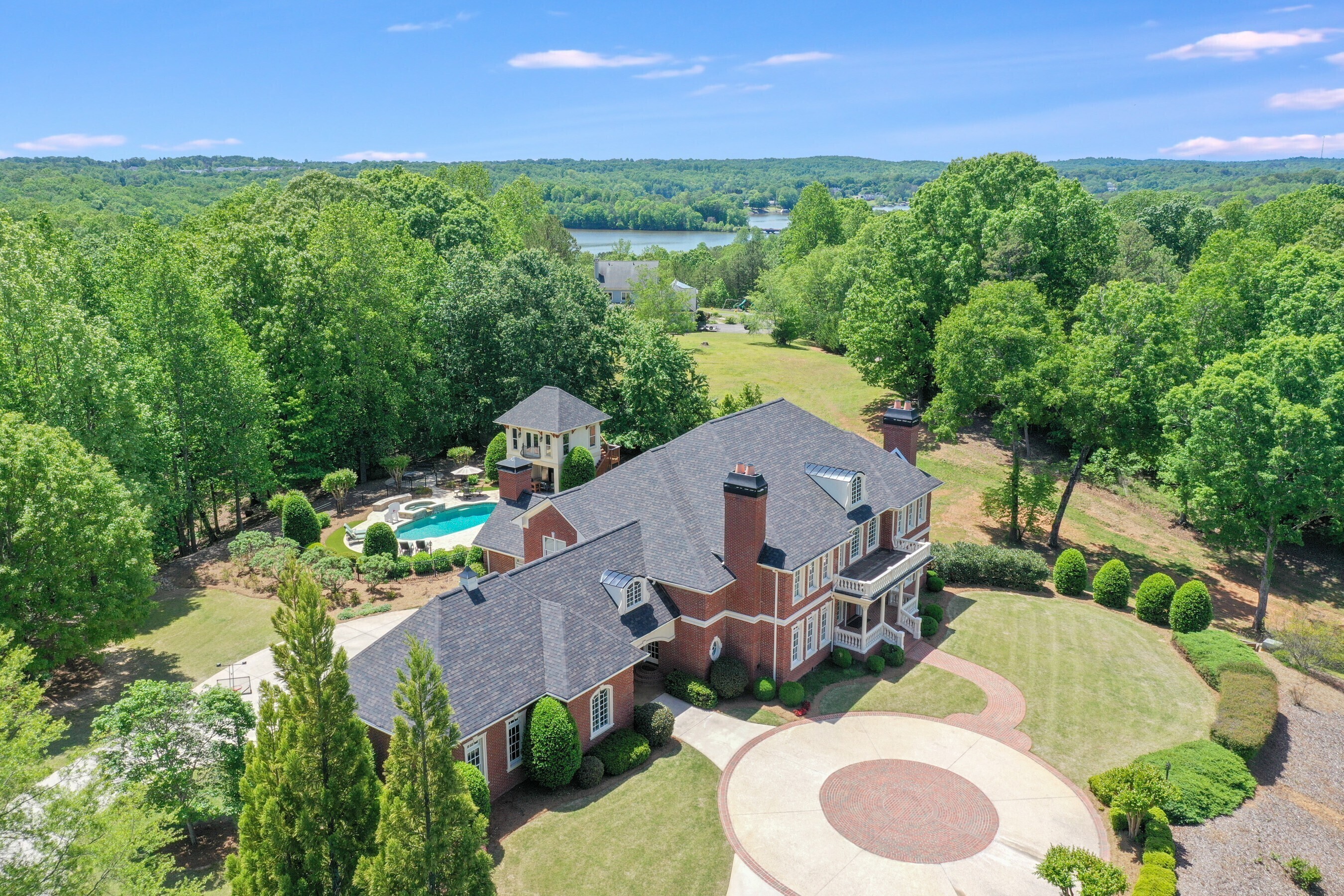 Luxurious estate home om 9.7 acres in The Country subdivision. This 6BR/5.5BA all brick home exudes excellence. Built in 2003 by the sellers, it has been immaculately cared for. The design of this home is perfect for families of all ages. The chef's kitchen has a Viking gas range, Sub Zero refrigerator and double oven. Gorgeous keeping room with stacked rock fireplace and wood beamed ceilings. You will enjoy the beautiful, heated Gunite pool and hot tub, outdoor kitchen, spacious brick patio, firepit and pool house with finished exercise room and full bath. On the main level you'll find an oversized Master with his and her walk-in closets, an additional laundry room and an office with coffered ceilings that could be used as a second bedroom with its own full bath. There are 4 large bedrooms upstairs wuth a finished bonus room with an additional entrance to the 3-car garage. The Gunite pool and pool deck has been refinished and a new roof was installed in April 2023.