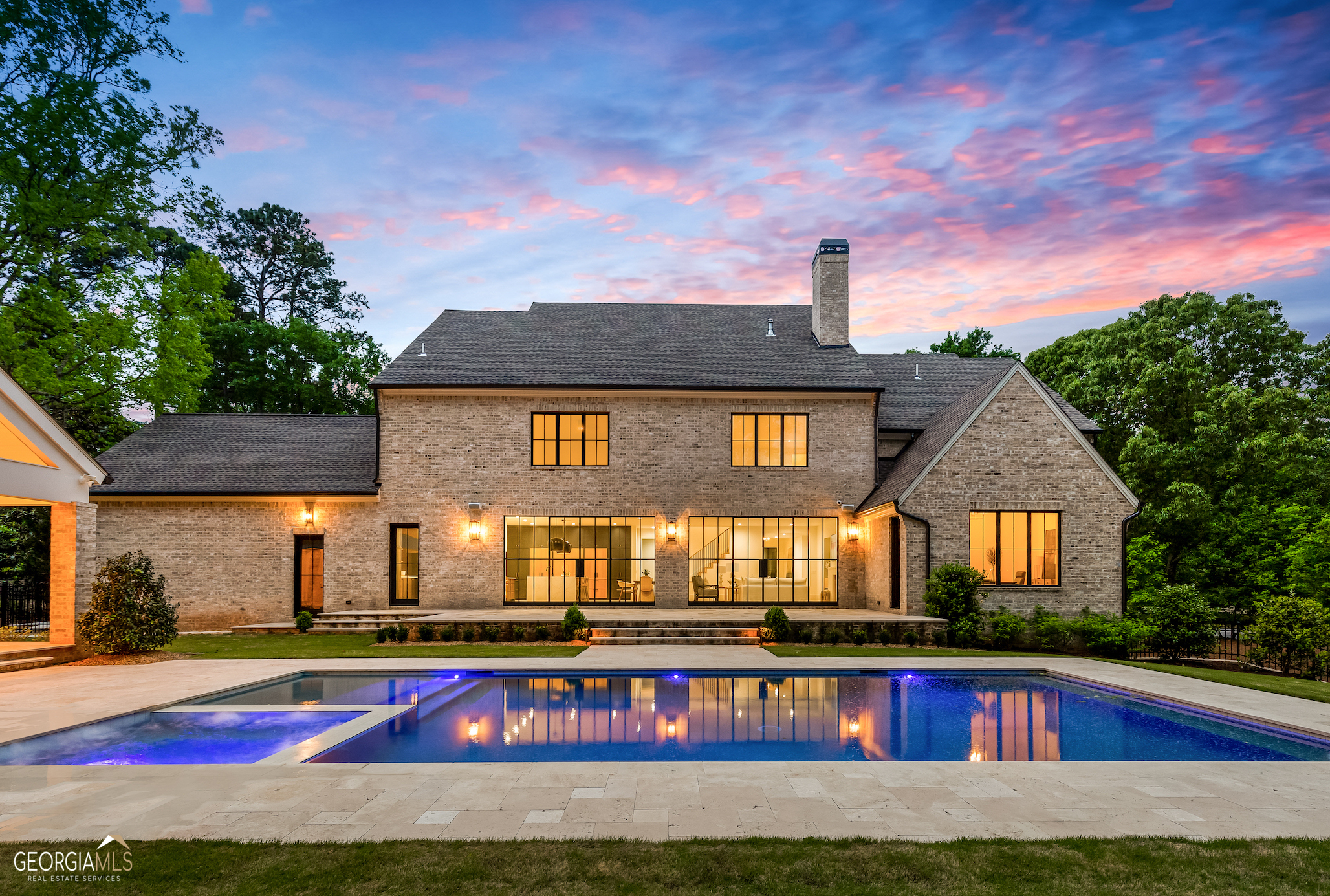 Situated in the heart of Sandy Springs with a pool/spa, welcome to this 6-bedroom, 5-bathroom, 2-half bathroom, 4-car garage, gated timeless home boasting luxury living at its finest. Accentuated with the finest materials and finishes throughout, you are welcomed with elevated 10ft ceilings, bright natural light, and an open floor plan that allows for a seamless flow between all living spaces. This grand gourmet chef's kitchen is an entertainer's dream! An expansive waterfall quartz island in the center of the room provides ample seating and counter-space. The professional-grade appliances, including a stainless steel oven / six burner cooktop, and side-by-side panel refrigerator, ensure that the chef at heart can create top-notch meals with ease. The kitchen opens directly to the spacious family room with a gorgeous stucco fireplace, custom built-in shelving, striking French glass doors and windows that open to the spacious backyard oasis creating the quintessential indoor/outdoor poolside living experience. Additionally, the main level includes a formal dining room with custom accent wall, wet bar, butler's pantry, mud room, laundry room and the primary suite. The luxurious primary suite is the perfect retreat for any homeowner, complete with a sitting area, office, and designer light fixtures. The spa-like bathroom features a freestanding soaking tub set in a soothing atmosphere, his and her vanities, a stunning marble shower with a rain shower head, and an extensive closet ready for customization. With its luxury amenities and tranquil atmosphere, this suite is the perfect place to relax and unwind after a long day. The second floor of this home boasts five spacious bedrooms, each one with plenty of closet space, and four full bathrooms. There is also a second entertainment area, with plenty of room for comfortable oversized seating, a pool table, or anything else your heart desires. This space is perfect for entertaining family and friends. The expansive backyard is an entertainer's dream, with a large pool and spa, cabana with a brick fireplace and half bathroom, and mature landscaping providing lots of privacy. Conveniently located within minutes of shops and top-rated restaurants that Sandy Springs and North Buckhead have to offer.
