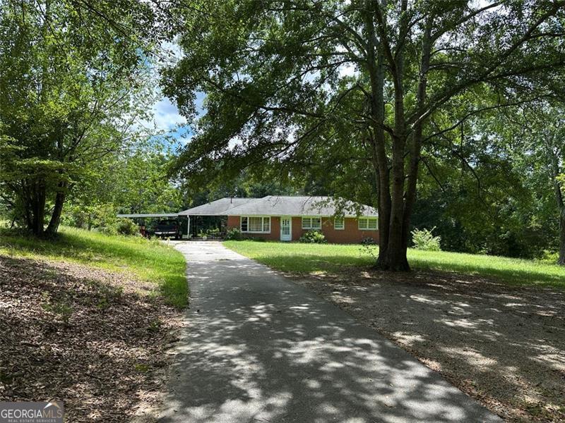 Discover the perfect balance of privacy, potential, and location at 1404 Ridge Road in Dallas, Paulding County. Nestled on 42 acres of beautiful, wooded land, this solid 1964-built brick ranch offers timeless construction with room to make it your own. The home features 3 bedrooms, 1 full bathroom, and 1 half bathroom across 1,175 square feet of living space. A 588-square-foot unfinished basement provides extra storage or the opportunity for expansion. With 4-sided brick construction, this home offers the durability and charm of a classic ranch-style layout in a peaceful, natural setting. Whether you're dreaming of a private homestead, looking for land to explore, or envisioning a future development project (subject to zoning guidelines), this property offers endless opportunities. Enjoy the quiet seclusion of nature while still being conveniently located to schools, shopping, and commuter routes. This is a rare opportunity to own a large acreage property with an existing home in one of Paulding County's fastest-growing areas.