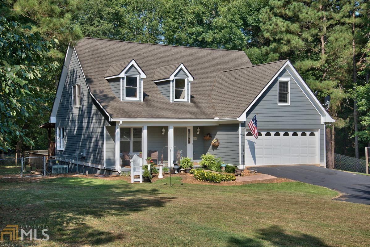 Imagine having your own woodland paradise, with an immaculate cottage nestled privately on nearly 2 acres. You ll enjoy views of a neighboring farm from the rocking chair front porch, and the massive 10x42ft covered back porch overlooks your private Lake Oconee inlet what a treat to launch your kayak or jonboat from your own backyard and explore the 19,000 acre lake! Entertaining will be easy with oversized deck; the backyard is already fenced. RV owners will love the graded pad and hookup. This home is right-sized with lovely architectural touches and the spaces you are looking for, including main level master suite, formal dining room and breakfast nook, and two bedrooms up plus a loft office. Gleaming marble tile counters complement the white cabinets.