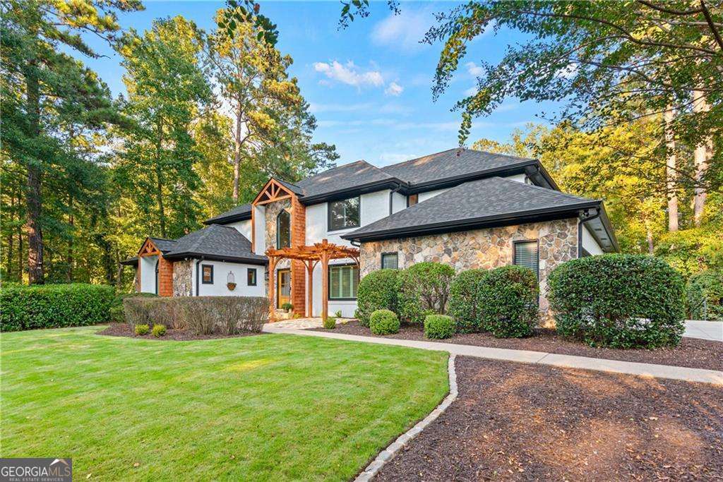 Nestled on an oversized private corner lot in the prestigious Estates section of Horseshoe Bend, this fully renovated home has been transformed from top to bottom. Every major surface and system has been updated, making it truly move-in ready. The heart of the home is a stunning open-concept kitchen with brand-new Z-Line appliances, flowing seamlessly into the spacious great room, dining area, and sunny breakfast nook. An oversized mudroom with a drop zone and a full laundry room add function and convenience, while a screened porch with fireplace and an outdoor kitchen extend the living space for year-round entertaining. The luxurious owner's suite offers a spa-inspired bath, sitting area with fireplace, walkout to the deck, and three oversized closets. Upstairs, three spacious bedrooms provide flexibility, while the newly expanded terrace level includes two bedroom suites, a large full bath, media room, glass-enclosed wine closet, and abundant storage. Step outside to your private backyard oasis featuring a heated pool and spa with two cascading waterfalls and three soothing bubblers on the tanning ledge, plus a fire pit, putting green, and fenced yard. New gutters, roof, and windows complement designer finishes throughout, blending timeless elegance with modern luxury-perfect for today's lifestyle.
