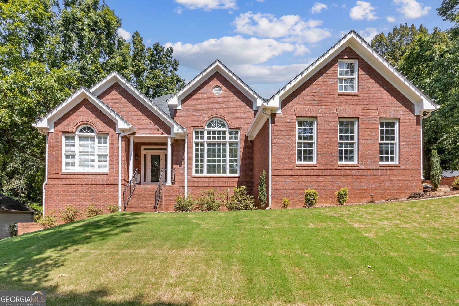 Located at 5985 Wigwam Way in the charming city of Flowery Branch sitting across from Lake Lanier, this residential property offers an inviting prospect in great condition. The heart of this home is undoubtedly its open floor plan, which creates an expansive and welcoming atmosphere. The living room is anchored by a fireplace, providing a focal point for gatherings and quiet evenings alike, further enhanced by the sophisticated touch of crown molding. Imagine the ambiance created by a crackling fire, casting a warm glow throughout the space. The kitchen serves as a culinary hub, boasting a backsplash, and a kitchen bar, providing ample space for meal preparation and casual dining. Stone countertops add a touch of luxury and durability, while the crown molding echoes the refined details found throughout the home. Step outside the sunroom to a beautiful fenced in backyard with an inground pool. This attractive property, featuring 3 bedrooms and 2.5 bathrooms offers a unique opportunity to embrace a comfortable and stylish lifestyle.