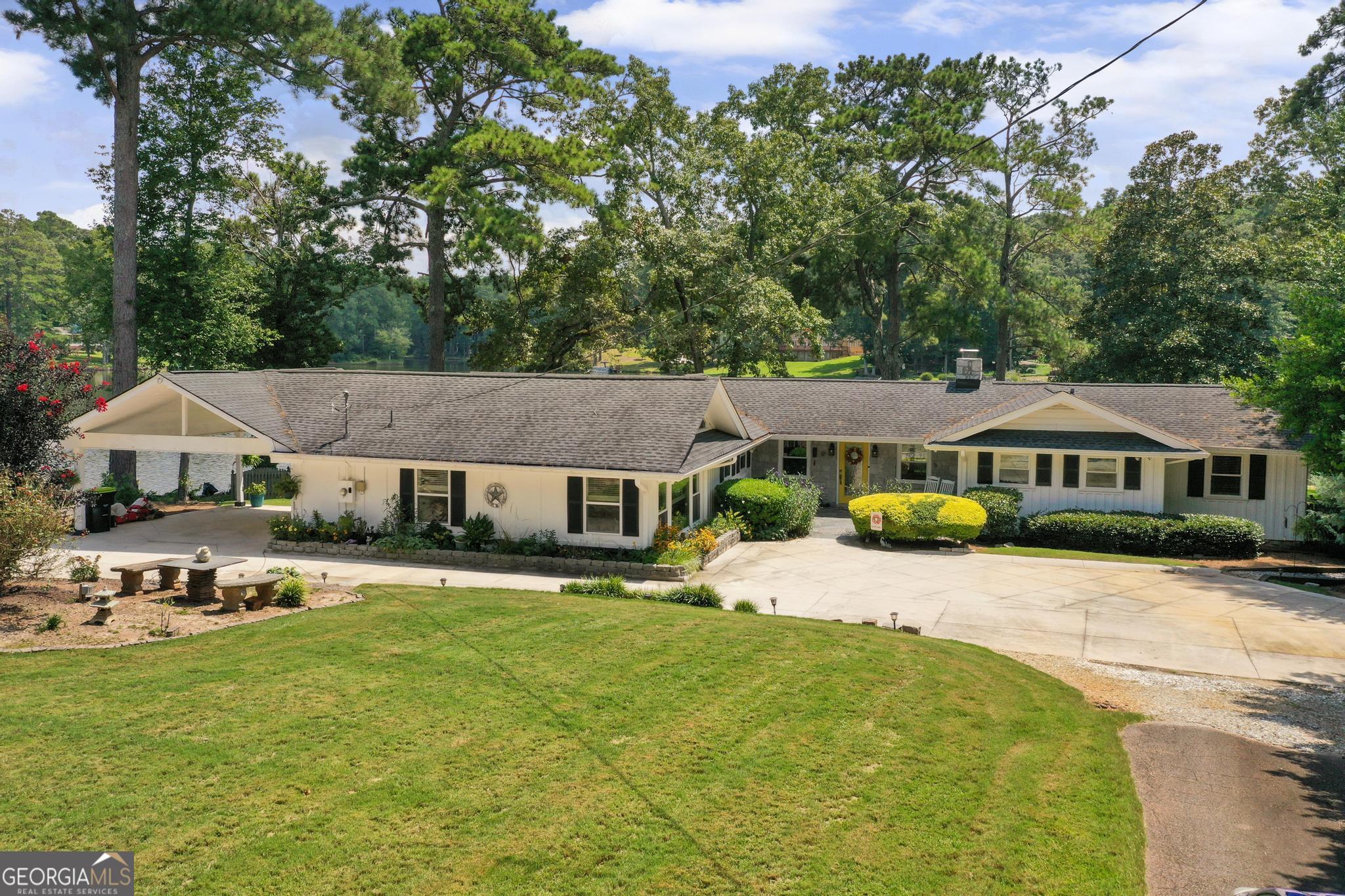 Discover peace, quiet, and natural beauty in this updated, well-maintained ranch style home located on Lake Jodeco. Perfect for nature lovers, boating and fishing enthusiasts, this property features its own covered boat dock, and approx 226 feet of water frontage making it easy to enjoy the water just steps from your door. Lake Jodeco is perfect for leisure, kayaking, fishing and quiet boating with a no wake zone. Inside, you'll find thoughtful updates and comfortable living spaces designed for year-round enjoyment. This well maintained home offers a total of 4 possible bedrooms and bathrooms with one being handicap-accessible Two of those bedrooms feature cozy fireplaces, creating warm retreats during cooler months. The 4th possible bedroom is currently being used as a large den/rec room. In addition, you'll find a living room/dining room combo with a wood burning insert in the fireplace, sunroom with stone floors, fantastic kitchen with great cabinet space, bonus room perfect for a home office, reading or whatever you need while still enjoying the lake view. The majority of this fantastic home has hardwood floors and no carpet. The views of the lake are absolutley stunning from multiple rooms in this home. The owner has spent so much time and money on this property to make sure that every little detail has been addressed from waterproofing the crawl space, replacing the windows and doors, replacing the hvac, deck, roof, gutters and adding gutter guards, adding a sprinkler system fed from the lake, extensive landscaping, adding a firepit and so much more. Surrounded by serene views and abundant wildlife, this home offers the perfect balance of comfort and outdoor living-whether you're watching the sunset over the lake, or simply enjoying the quiet atmosphere. Don't miss your chance to own this inviting lakeside retreat where relaxation and recreation come together in this nature lover's paradise. A slice of heaven just 20 minutes from the Atlanta airport.