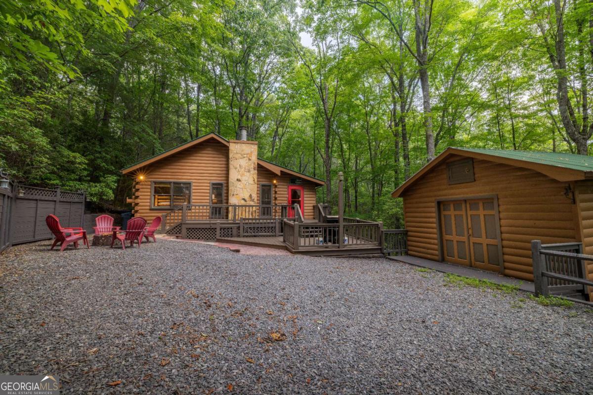 Welcome to your tranquil escape in the heart of Cherry Log! Nestled on a serene 1.1-acre lot within the desirable Cherry Lake subdivision, this charming 3-bedroom, 2-bathroom cabin offers both privacy and community amenities, including exclusive access to the picturesque Cherry Lake. Currently serving as a successful short-term rental, this inviting retreat also presents a fantastic opportunity for a full-time residence. As you step inside, you'll be welcomed by the warm ambiance of the main level's cozy living room, complemented by two comfortable bedrooms and bathroom. Descend to the fully finished basement, where extra sleeping accommodations await in the bunk room, alongside a vibrant game room perfect for entertainment. The terrace-level patio invites you to unwind in the hot tub, surrounded by lush woods, offering an idyllic setting for serenity and seclusion. Whether you're seeking a lucrative investment or a peaceful home to call your own, this cabin in Cherry Log is a delightful blend of comfort and natural beauty. Don't miss the chance to make it yours!