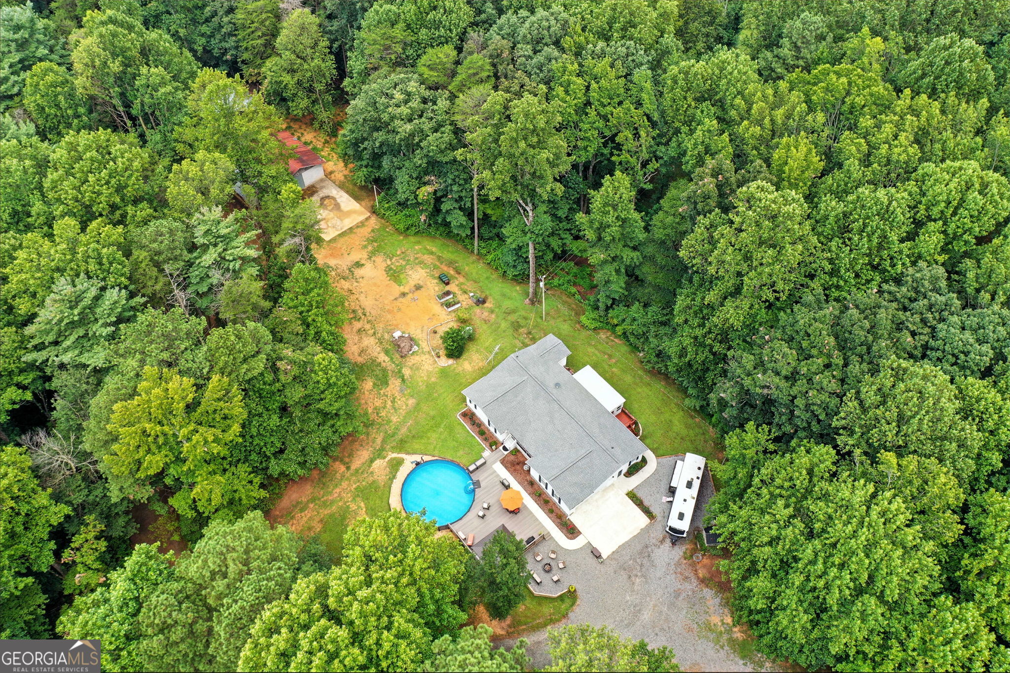 Country living with room to grow on acres! This well-maintained 3-bedroom, 2-bath ranch home is situated on 5.9 acres of peaceful land-perfect for those looking for space and privacy. Property has many additional features like a salt water pool, a pole barn, recently cleared land and healthy well water. Inside, the home features a functional layout with a cozy living area, spacious kitchen, and comfortable bedrooms. The master bedroom is on the main level and includes an en-suite bath and a walk-in closet. Both of the secondary bedrooms are generously sized and have walk-in closets. The living room has a gas log fireplace, a bay window and access to the screened front porch. The country kitchen is well equipped and has a kitchen peninsula with seating for 4. The eat-in kitchen nook has room for all your guests. The recently added back sunroom is perfect for morning coffee or for entertaining. There is a large pantry/ storage room off the kitchen perfect to keep all of your extra items. Step outside and enjoy summer days at the above-ground salt water pool and relax and entertain on the large Trex deck, a durable, low-maintenance surface built to last! Entertain your guests at the fire pit under the brightest stars found only in the country away from the bright city lights. Whether you're hosting friends, enjoying a quiet morning coffee or end-of-day beverages, the outdoor space is sure to impress. Included on this property is a separate barndominium in process with a large parking pad/slab that has a newly installed septic system. This project was started by the seller and it offers a fantastic opportunity to finish this project your way. Cabinets, new kitchen appliances and a water heater will be included. Large concrete pad next to this structure is in place for a parking area or when you build the new garage. Whether you're dreaming of a guesthouse, workshop or studio, the groundwork is already in place. There is a large Pole barn to cover a boat or RV. With almost 6 acres to roam, there's plenty of room for animals, gardening, or simply enjoying nature. No HOA. Bring your vision and enjoy all the benefits of country life just a short drive from Ellijay. So many upgrades to list here. This property has a new Generac whole-home back up power. Crawl space under this home has a recently installed vaper barrier with insulation and is humidity controlled. Don't miss the chance to make this property your own-schedule your private tour today!
