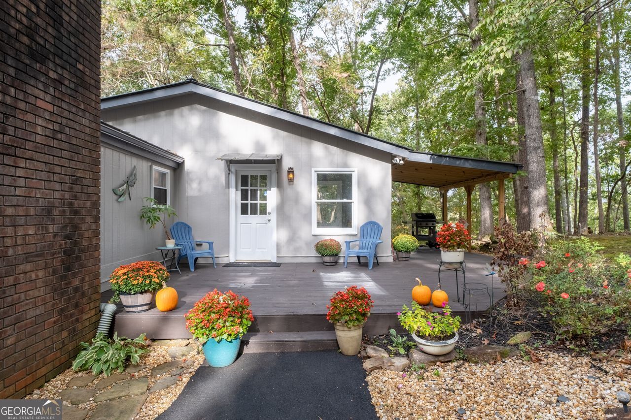 Priced below recent DS Murphy Pre List Appraisal. No HOA. 3 Gorgeous acres perfectly located in Dawson county, just over the Forsyth County line. Large mature wooded corner lot with Kelly Bridge road frontage. The long circular paved driveway has a 2023 Carport, 2023 Large Exterior Storage Building. The outside spaces are the BEST! It is up high enough to have an amazing breeze. Covered and screened front porch and a large back deck, partially covered area perfect for grilling. Its a beautiful place to enjoy friends around the firepit. It's private and It's perfect. The interior is equally as pleasing as the location and outdoor spaces. It has been recently renovated with, New Metal Roof, Gutters, New exterior and Interior Paint, New Flooring, new kitchen cabinets and the cutest coffee bar. There is a masonry wood-burning fireplace with wrought-iron double doors in the main room. Agent/ Owner