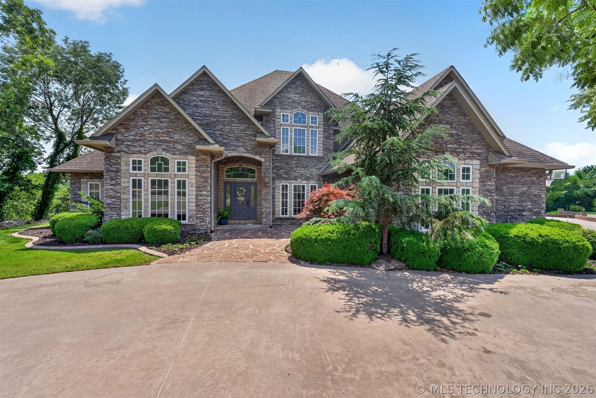 Stone exterior residence featuring a prominent arc