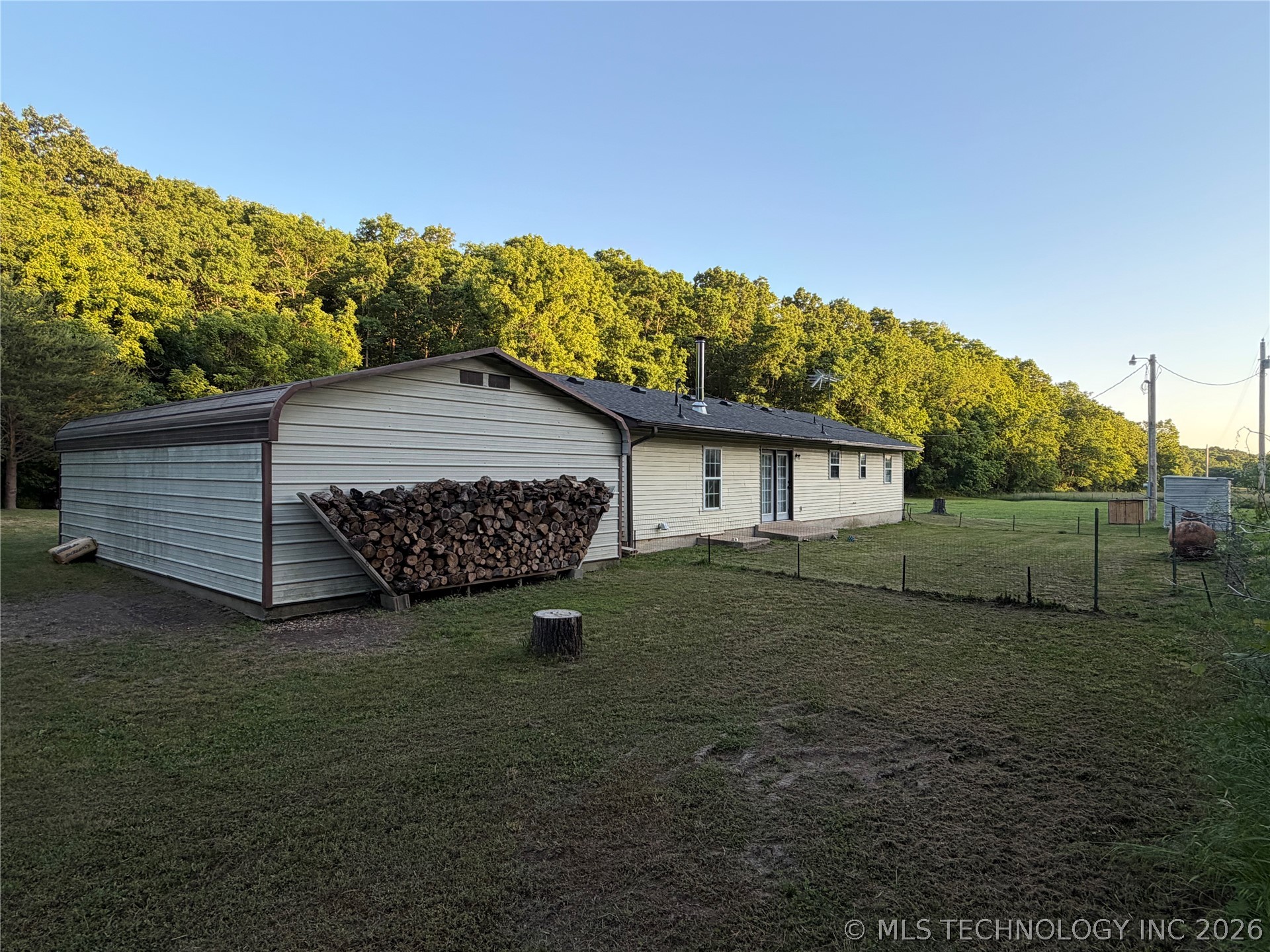 Rear exterior featuring a detached metal carport,