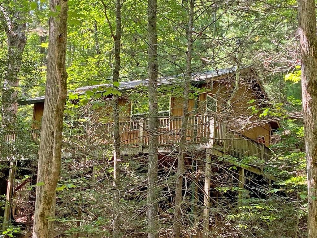 LIL' CABIN IN THE WOODS on 0.78 acres that adjoins the Chattahoochee National Forest. And a rip-roaring whitewater trout stream is but a short and easy walk away, into the Chattahoochee National Forest!
Nestled among the trees, simple but cute comes to mind when you look at the cabin. Open concept with vaulted ceilings, this two bedroom, one bath home feels roomy and inviting. The wood stove warms both the ambiance and the cabin in the winter and the furnishings are included, bring a toothbrush and expect to leave your daily stresses behind. Located on a private road, paved and gravel. But you're conveniently located north of Downtown Dahlonega and gosh you pass by Wolf Mountain winery on the way, approximately one mile from cabin.
Just a minute's walk away from the cabin, there's an easy trail into the Chattahoochee National Forest alongside the whitewater Yahoola Creek and you can wander to your heart's content within the Chattahoochee National Forest or climb across the boulders on the Yahoola Creek to splash and play. Pack up your troubles and toss 'em out the car window and come to relax, play, hike, enjoy some wine or dinner in the oasis that is Dahlonega.