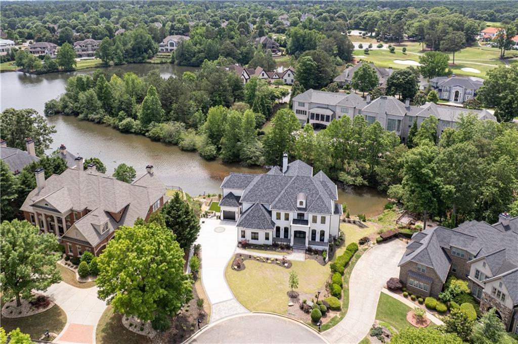 Timeless luxury. Uncompromised craftsmanship. Stunning lake views. Experience the pinnacle of country club living in this NEW CONSTRUCTION home from Hyde Park Homes, Inc in prestigious, gated Sugarloaf Country Club. Meticulous pursuit of perfection is evident in every detail of this home, and the home has some wonderful attributes such as TWO FULL MASTER SUITES PLUS ELEVATOR to all three levels. The stage is set as you enter the front iron doors into the luxurious and bright foyer with impressive and unique circular staircase surrounded by windows and handsome marble floors. The main floor is a showcase of elegance and perfect for entertaining with the living room and stylish bar open to the dining room with lake views. Adjoining the formal areas is the Chef's Kitchen with its white oak cabinets, high end stainless appliances, gorgeous Calacatta Marrochino quartz counters and backsplash. Adjoining the kitchen are the breakfast room and spacious keeping room with modern fireplace, and just around the corner is a scullery (or spice kitchen) which provides a second kitchen area for entertaining both indoors as well as outdoors on the porch with lake views. The luxurious main master suite is also on the first floor with continuing lake views, a spa-like bathroom and sumptuous closet. Completing the first floor are the stately study, extra-large laundry room, mud room, and ELEVATOR to all levels. A second full master suite can be found on the second floor with great lake views, two closets, and opulent bathroom suite. There are an additional three bedroom suites and a second full laundry on the second level. The finished terrace is definitely one-of-a -kind with its 12' ceilings, second full kitchen/entertaining bar, wine room, huge theatre room, fireplace, game room PLUS billiards room, exercise room, gorgeous guest bedroom suite and so much more! A few more exquisite details include Pella exterior windows and doors, 5" White Oak Hardwoods, 8" solid masonite interior doors on all levels and stunning landscaping package. Your new home is ready for move-in!