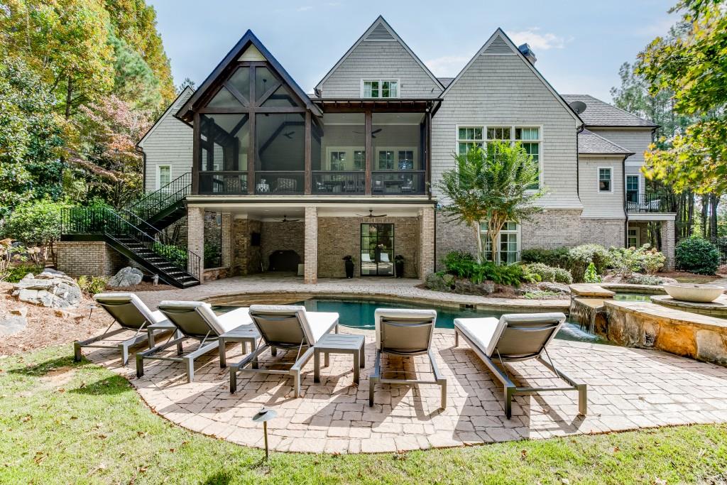 This 6-bedroom, 7.5-bath estate, fully renovated to perfection, is a true showcase of luxury and high-end finishes. Situated on a professionally landscaped lot, the property features a saltwater pool, double spa, and expansive outdoor living spaces offering unmatched craftsmanship and attention to detail. The main level opens with a grand entrance, featuring a circular driveway and double iron and glass doors. Inside, the main floor is highlighted by the owner's suite with a private balcony, a spa-like bath with Bianco Carrara marble, and a custom closet with marble countertops. The two-story living room, with a stone fireplace, flows into a gourmet kitchen outfitted with honed Carrara marble countertops top-tier appliances, and hidden pantry. Imagine cozy evenings by the gas fireplace on the screened-in porch or hosting intimate outdoor dinners in this serene setting. Additional exceptional features on the first floor include a custom wine cellar, Genesis elevator, dog shower, and a spacious, well-appointed laundry room. The second level boasts a second owner's suite with a versatile study/teen or in-law living area equipped with a microwave and ice maker. This floor also includes a junior owner's suite, two additional bedrooms with en-suite baths, and a secondary laundry room, ensuring effortless living for family or guests. Designed with entertainment in mind, the terrace level is a destination in itself, featuring a state-of-the-art home theater, billiards area, game room, and private spa. A third laundry room and a well-equipped kitchen ensure effortless hosting, while the en-suite bedroom with custom cedar double bunk beds adds charm and practicality for family or visiting guests. This Smart Home is equipped with cutting-edge technology, premium appliances, and designer fixtures, offering a level of refinement that surpasses even new construction homes. Located in The River Club, a haven of exclusivity, residents enjoy access to the Greg Norman premier private championship golf course, a Family Lakeside Sports Center, state-of-the-art Fitness Center, dining and spa services.