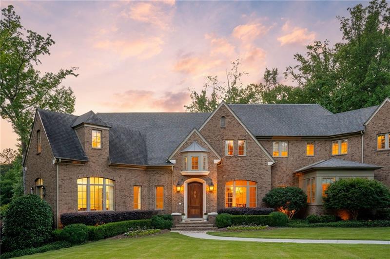 Framed by a canopy of mature trees, this stunning Harrison Design newer construction home dazzles with a refined sense of luxury and understated elegance and is situated on over 2 acres of private land. The spectacular 2-story foyer sets a tone of subtle sophistication with a dramatic curved staircase and elegant arched doorways leading to the bright and spacious great room with a wall of French doors that open to one of several outdoor living spaces. Designed for everything from large scale parties to the flow of everyday life, the stunning kitchen features custom cabinetry, stone counters and back splash, a suite of premium appliances and a large center island overlooking the cozy fireside keeping room with access to a covered patio, outdoor fireplace and gorgeous infinity-edge pool. The main level primary suite creates a welcome sanctuary with a cozy sitting area, morning bar, fireplace and private balcony along with two separate walk-in closets and a luxurious bathroom with dual vanities, walk-in shower and separate soaking tub. The upper level boasts four spacious ensuite bedrooms and convenient laundry room. Finished to perfection, the daylight terrace level has 12-foot ceilings and provides additional living and entertaining zones including a 10-seat theatre room/golf simulator, home gym with sauna and steam shower, hair salon, oversized game room and private guest suite. 2 flat play yards and fire pit area, 4 car garage. Truly a perfect 10!