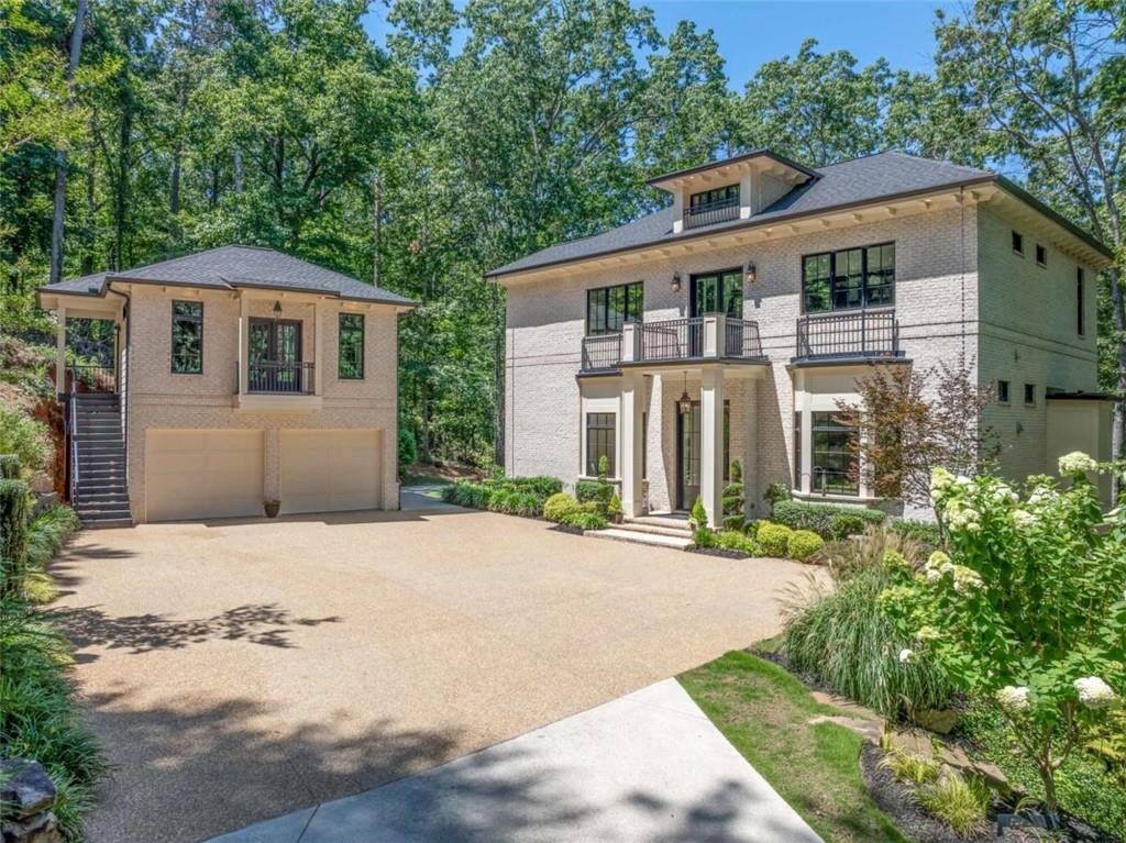 Just in time for summer . . . live the ultimate lake life in this exquisite custom-built one of a kind like new home. Boasting Bald Ridge Creek location with a single slip private dock on year-round deep water with two jet-ski lifts. Set on a gently sloping lot with a flat back yard, the home offers panoramic sunset lake views from all 3 levels of luxury living. This lot is surrounded by privacy. Exceptional outdoor living with an oversized open porch and two covered porches. Stone fire pit and patio that flows seamlessly toward the dock path. Crafted with three sides custom brick and a separate two car garage with ready to finish executive office or separate guest quarters. This head turning residence impresses from the moment you arrive after the protective 300 foot driveway with landscaping to perfection. Awesome pebble rock motor court for those lake parties and family gatherings. This is a five out of five: location, great water, ample parking, storage and exquisite like new home! Upon entering through the 9 foot aluminum clad statement doors at the first floor open plan dream home. Five 5 x10 foot picture windows flank the modern gas fireplace surrounded by gorgeous book matched porcelain slabs. Over 13 foot high ceilings complement the 10 1/4 inch wide, 10 foot long, oil finished hardwood floors. You will notice the LED lit spiral staircase for secondary access to the 1200 S.F. Master Suite. The kitchen boasts modern, glossy white, frameless cabinets with oversized porcelain island including double waterfalls. The matching over height porcelain slab backsplash with pot filler and custom down lighting is world class. The motorized cabinets, panelized appliances, including ice maker and push to open Frigidaire are rarely found in custom built homes. Finishing the main living space is the walk-in pantry and open dining room with coffered ceiling, crystal chandelier and huge picture window to pure serenity. Designed for multi-level entertaining, the finished terrace level is a dream complete with a large living space. Two bedrooms and two full baths and a storage room await. A flat backyard, firepit & dock path from the terrace level make this secluded space a dream. The over 1200 square foot master suite on the third floor is exquisite. Oversized closet, laundry room, breakfast kitchen with sink and refrigerator / freezer drawers included. A desk area overlooking the front courtyard is perfect for seclusion. Front and lake facing porches. Master bath boasts floor to ceiling Italian marble, oversized stone soaker tub, his and her vanities, curbless shower with secondary rain head and wall hung toilet. A separate 2-car garage offers potential for an income-generating apartment or private guest quarters. Professionally landscaped grounds include year round blooms, rock waterfall and irrigation system. Approved side setback reduction allows for a future pool to elevate the estate feel. This one-of-a-kind Lake Lanier estate blends luxury, comfort, and unbeatable lakefront access—designed for those who want to enjoy every moment of lake living. Discover the unparalleled lifestyle that comes with living on the breathtaking shores of Lake Lanier, where every day feels like a vacation. This stunning lake is not just a picturesque backdrop. With your boat docked just steps from your home, you can effortlessly cruise to popular lakeside restaurants for a dinner, where you can enjoy lifestyle music with your friends and family. Embrace a lifestyle filled with sun-soaked days spent on the water, cozy evenings by the firepit, and a close knit community that cherishes the beauty of nature. Living on Lanier means not just finding a home, but discovering a vibrant way of life that celebrates both adventure and tranquility. This truly is the perfect place to call home.