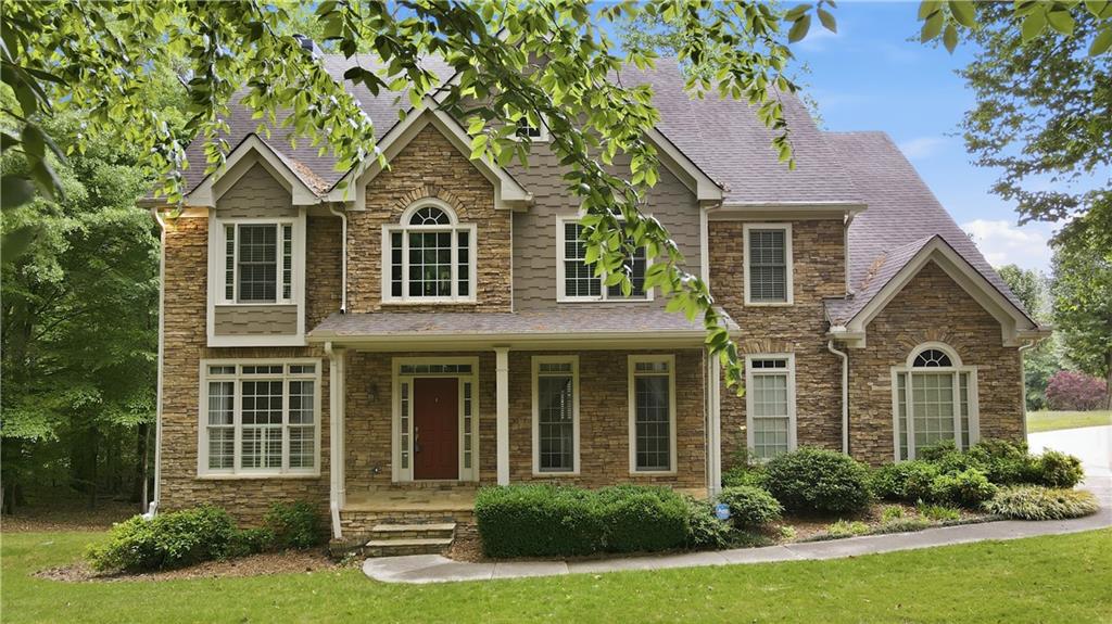 Stone and shingle exterior with a prominent red entry door
