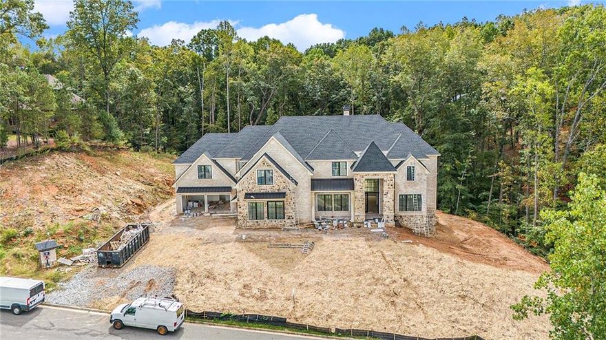 Welcome to 240 Traditions Drive! Discover your oasis in this custom home perched on Lot 8 in the beautiful Echelon community of Alpharetta. Set on a private 2.3-acre lot surrounded by hardwoods and a serene creek, this property offers tranquility while remaining conveniently close to local amenities. When completed, with over 10,000 sq ft of living space across three levels, this residence will masterfully blend elegance, functionality, and modern design. The main level welcomes you with soaring 12' ceilings that invite natural light into the expansive open-concept layout. Enjoy cooking in a chef’s paradise featuring quartz countertops, a large island, custom solid maple cabinetry, and top-tier stainless steel appliances. The kitchen seamlessly connects to the breakfast area, dining, and living spaces. Effortlessly entertain or relax as you transition outdoors to the covered veranda, perfect for enjoying fall evenings. A fully appointed second scullery kitchen is discreetly tucked away, ideal for catering or additional meal prep. The main level includes a study desk, a Butler's pantry with a beverage fridge, guest en suite along with a spacious laundry room and full "pool" bath conveniently accessible from your future pool, should you opt for one. Ascend the elegant open-riser staircase to the upper level, where you'll find a generous Owner's suite equipped with its own laundry, a luxurious soaking tub, an oversized shower, and fully soundproofed walls for uninterrupted relaxation. Additionally, there are 4 other well-appointed secondary en suites for family and guests. The finished terrace level is designed for leisure and entertainment, offering ample space for an office, gym, game room, and more gatherings to host at the full wet bar. Get ready to enjoy movie nights as the pre-wired unfinished home theater room is ready for your personal touches. Additional Features include an elevator shaft for future convenience, 4” solid hardwood floors on the main and upper levels, quartz countertops throughout, impressive 10" ceilings on the upper and terrace levels, and pre-wired for 3 EV chargers in the garage. *Lot grading in process.*

Echelon is renowned for its stunning golf course, rated the 11th best in Georgia by Golf Magazine. Designed by acclaimed architect Rees Jones, the semi-private course spans 600 acres of rolling hills with breathtaking views and a 32-acre practice facility. Located within a short drive to Avalon, Halcyon, Vickery, Crabapple, and Downtown Roswell, Hwy 9, GA 400,  shopping, dining, and entertainment. Welcome to a life of luxury at 240 Traditions Drive!