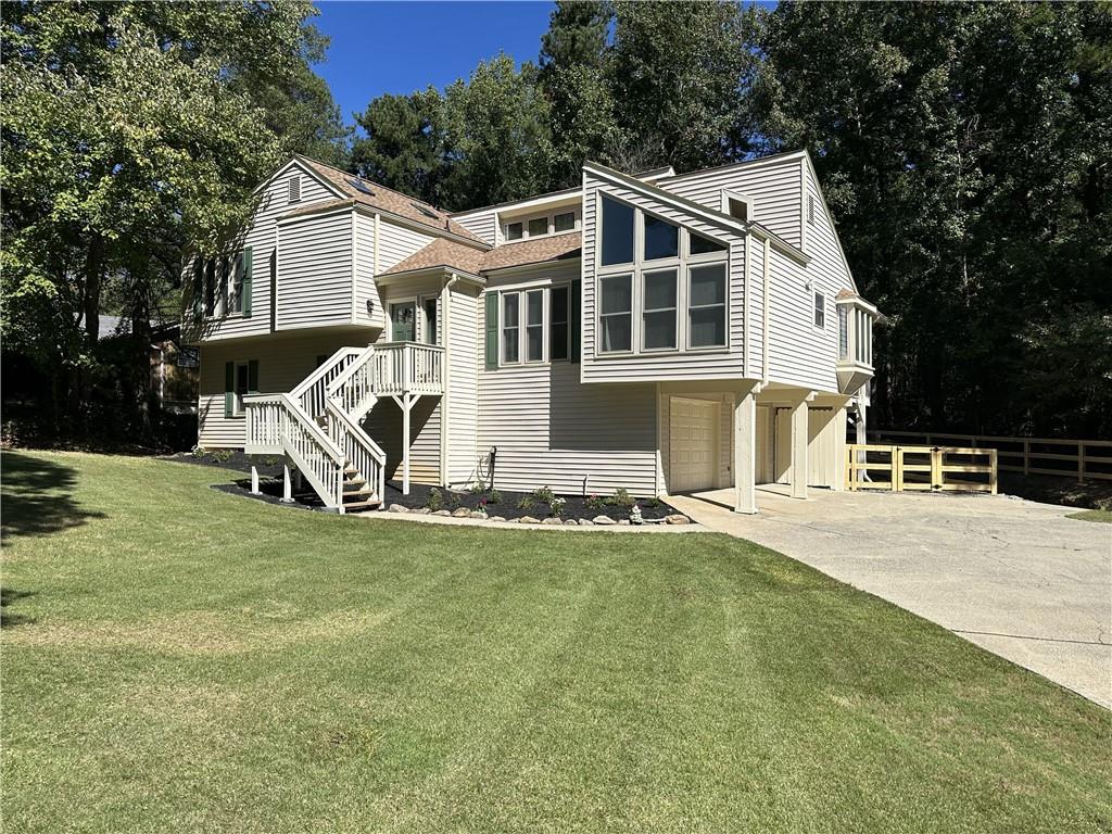 Welcome to your dream home in the sought-after Pope High School district! This stunning 4-bedroom, 3-bath residence boasts an inviting open layout with high ceilings and a cozy fireplace, perfect for gatherings. The updated chef’s kitchen features granite countertops, white cabinets, and ample space, seamlessly connecting to a separate dining area and a bright breakfast nook that opens into a spacious sunroom with picturesque views. The private, fenced backyard offers a storage area and a generous deck space, ideal for outdoor entertaining. Retreat to the expansive primary suite with abundant closet space and a fully renovated, spa-like bathroom. The upgraded guest bathroom adds a touch of modern comfort, and new updated flooring throughout the home. The lower level provides a second living area with a fireplace, an additional bedroom, and easy access to a beautifully updated full bathroom. Conveniently located near park, freeways, shopping, and stores, this home offers the perfect blend of style, comfort, and location. Don’t miss out—this gem won’t last long!