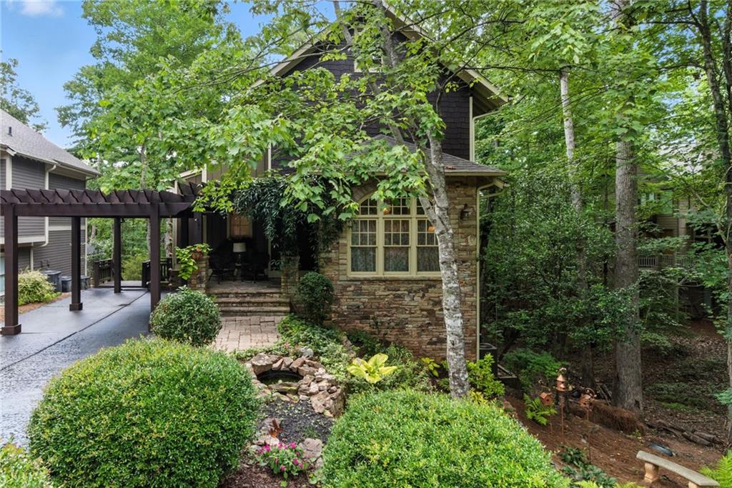 Craftsman elegance meets modern comfort in a premier mountain setting near Clubhouse, Main Gate, and Amenities. Beautifully appointed, EarthCraft-certified home with roofed carport nestled in the desirable Choctaw Village neighborhood of Big Canoe. Former model home exudes rustic craftsman charm while boasting energy efficiency and upscale modern upgrades throughout.
The recently remodeled kitchen is a chef’s dream, featuring high-end Café appliances, quartz countertops, custom cabinetry, open shelving, a pot filler, designer pendant lighting, and a stylish range hood and backsplash. The pantry has been redesigned with additional cabinetry, open shelves, and quartz surfaces for both form and function.
Main-level owner’s suite offers convenience and comfort with heated bathroom floors, while a spacious guest suite upstairs, and additional bedroom and bath on the terrace level provide privacy for family and guests. The walkout lower level also includes a family room, along with plenty of storage and a utility room making it ideal for entertaining, relaxing and functionality.
Outdoors, enjoy a beautifully terraced front yard with dry stack stone walls, and extensive landscaping. The stone front porch is also roofed so as to provide pure relaxation. The back yard includes seasonal mountain views, an outdoor barbecue area perfect for gatherings.
Located in walkable, friendly Choctaw Village, this home is just a short stroll from Big Canoe’s clubhouse, golf course, dining, and amenities. If you’re seeking the perfect blend of timeless mountain style, modern luxury, and energy-conscious living, 90 Choctaw Ridge is a must-see.
Located just an hour from Atlanta, Big Canoe is a private, gated mountain community offering resort-style amenities at the foothills of the North Georgia Mountains yet within an hour of Atlanta. Buyer to verify all information and dimensions deemed important.