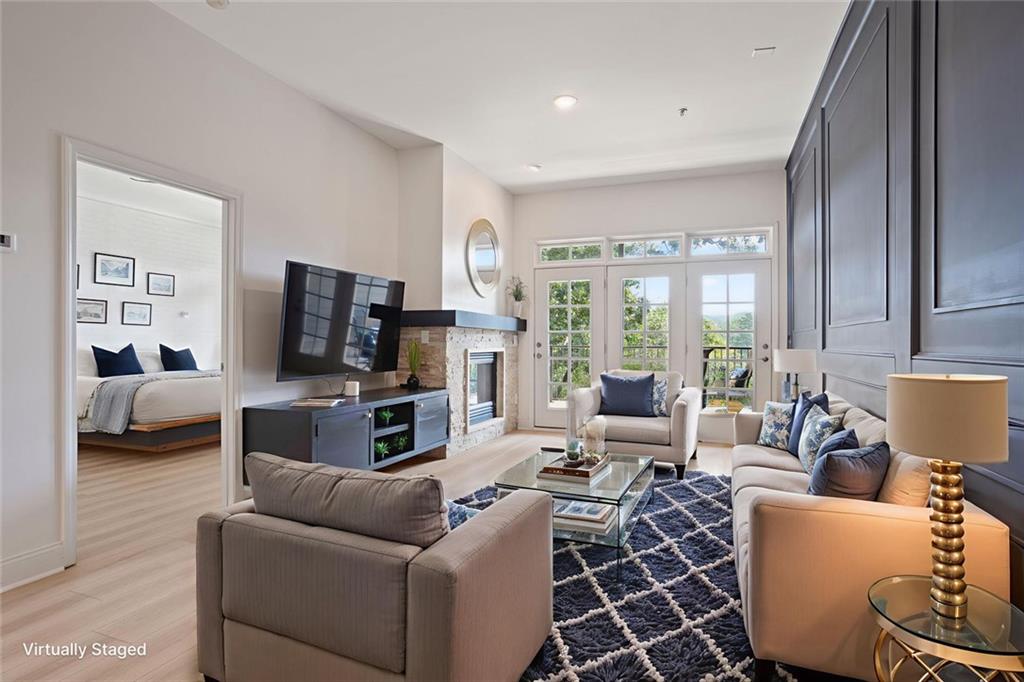 Fabulous Luxury Condo in the Heart of Roswell! Exceptional opportunity to own this stunning 2 bedroom, 2 full bath condominium in sought after Mill Street Park! Enjoy breathtaking treetop canopy views of Vickery Creek Nature Preserve and waterfalls! Vickery Creek Trail offers 8 miles of Nature Trails for walking, hiking, dog walks and refreshing dips into the River on a hot day! Located in Historic and charming Mill Village with its Covered Bridge and a short walk to Roswell Square's inviting restaurants and coffee house. Trendy Canton Street restaurants, entertainment and shopping are minutes to the north and the Chattahoochie River and new Riverwalk Trail is minutes to the south, From the convenient covered Parking deck, enter 512 Creek View Lane and you are welcomed to a freshly painted well appointed unit with wonderful blend of Style and Function.
Enhanced with new flooring throughout, the bright open concept floor plan with walls of light creates a truly inviting living space. The entry Hallway leads to the Exquisitely updated Chef's Kitchen offers a full compliment of stainless professional grade appliances, custom cabinetry, New Quartz Countertops and open views to the dining and living rooms. Bring the outside in with the amazing covered back porch which spans the length of the unit and offers wonderful space for dining, relaxing mornings and private peaceful views of Vickery Preserve. The main living space incorporates a custom crafted accent wall built-in cabinetry and gas fireplace.The sumptuous Owner's suite includes a custom painted brick accent wall, tray ceiling, ceiling fan, inviting fireplace, huge walk-in closet, and Double barn door leading to spa-like bath with oversized shower and double vanity. The spacious second bathroom has entries from the main hallway and the second bedroom and features stunning new quartz countertop, Tub / shower combination and elegant designer gold fixtures! The HOA pays for: Water, Trash Pick-up, exterior Maintenance, Grounds Maintenance, termite coverage and all common area landscaping and maintenance. With it's fantastic location, close to shopping, dining, outdoor living and entertainment, and overlooking the nature preserve, 512 Creek View Lane is the perfect spot for exceptional Roswell living and entertaining!