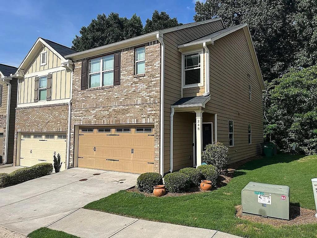 Welcome to this inviting end-unit townhome that combines charm, space, and convenience! Featuring three bedrooms and two and a half bathrooms, this two-story residence offers a bright and open layout designed for both comfort and functionality.
The main level showcases gleaming hardwood floors and a cozy gas fireplace, seamlessly connecting the living, dining, and kitchen areas—perfect for entertaining or everyday living. The chef’s kitchen includes stainless steel appliances, elegant granite countertops, ample cabinetry, a walk-in pantry, and generous counter space for meal prep. Upstairs, the primary suite is a true retreat with its spa-like en-suite bathroom, oversized soaking tub, separate walk-in shower, dual vanities, and a spacious walk-in closet. Secondary bedrooms are generously sized and feature excellent closet storage. Additional highlights include a private deck overlooking a wooded backdrop, ideal for morning coffee or evening relaxation, as well as an attached garage for convenience and extra storage. Situated in a desirable neighborhood just 3.4 miles from downtown Woodstock and under 8 miles to Lake Allatoona, this home offers easy access to top schools, shopping, dining, and major highways including I-575 and I-75.
With its thoughtful layout, modern finishes, and unbeatable location, this townhome is ready to welcome its next owner. Don’t miss your chance—schedule a showing today!