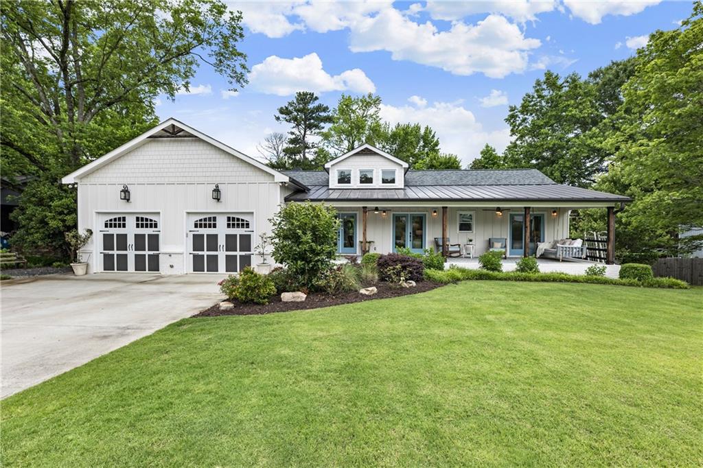 Rare, Fully Renovated Ranch with Basement in the Heart of Downtown Alpharetta. This is not your typical renovation—this designer home underwent a full rebuild, complete with a dramatic vaulted addition and two-level west wing expansion, transforming it into a one-of-a-kind modern farmhouse with timeless character and luxury finishes throughout. Perfectly situated on a flat, fenced lot in one of Alpharetta’s most coveted walkable neighborhoods, the home welcomes you with a bed swing front porch, stained tongue-and-groove ceiling, and dual ceiling fans—an idyllic spot for lazy summer evenings. The charm continues inside with three sets of French doors, a striking vaulted shiplap ceiling, and wide-plank hardwood floors bathed in natural light from high transom windows. The open-concept main level is anchored by a chef’s kitchen featuring: A large quartz island with seating, Stainless steel appliances, including a 6-burner slide-in gas range, Custom vent hood, microwave drawer, French door refrigerator, and dishwasher, Porcelain apron sink, glass-front cabinets, floating shelves, and large pantry. The open dining space accommodates both formal and casual gatherings with ease, flowing seamlessly into a spacious family room with multiple layout options. Down the hall, the laundry/mudroom is as functional as it is stylish, boasting a custom dog wash station, folding counter, hanging space, and future locker potential. Two secondary bedrooms share a beautifully appointed bath with a large walk-in shower. Privately tucked away at the other end of the home is the primary suite retreat, featuring: A gas fireplace and designer accent wall, A spa-inspired bath with soaking tub, dual vanities, oversized walk-in shower, and custom closet with vanity, Private access to the screened-in deck with fireplace, easily convertible to a 4-seasons room for year-round entertaining. The finished terrace level offers even more flexible space with a guest suite and full bath, a gym/office/media room, and a huge unfinished area ideal for storage or workshop. Step outside to your private oasis offering a Flat, fenced backyard with covered patio, hardscape fire pit, goldfish pond, and raised garden beds, Expansive grilling deck perfect for dining alfresco under the stars! Additional upgrades include dual HVAC systems, whole-house water filtration, front and back irrigation, and an oversized driveway with parking for 6+ vehicles in addition to the two-car garage. All this just minutes from Downtown Alpharetta’s vibrant restaurants, shops, music venues, parks, trails, and weekly Farmers Market—accessible via a private neighborhood shortcut. Don’t miss this rare opportunity to own a completely reimagined home in one of Alpharetta’s most desirable locations.