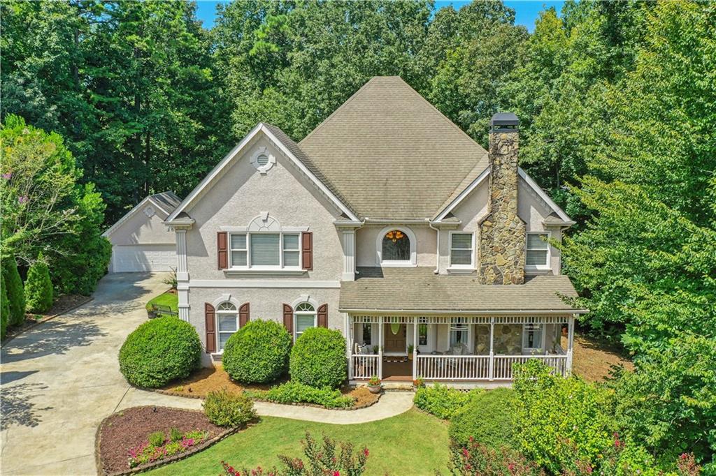 Nestled on a quiet, landscaped, cul-de-sac lot in the prestigious Lake Sovereign community, this spacious 5-bedroom, 4.5-bathroom executive estate is calling you home. Relax on the welcoming front porch before stepping inside and falling in love with the rich hardwood floors, high ceilings, arched doorways, and crown molding. The lofty 2-story foyer is flanked by a light and bright formal living room with a pretty bay window and cozy white fireplace. The separate dining room flows into the huge, cheerful, eat-in kitchen with hardwood floors, white cabinets, brushed nickel hardware, plenty of storage, a stainless-steel refrigerator and dishwasher, double ovens, separate gas cooktop, built-in desk, breakfast bar, and large eating area with vaulted ceilings and a view to the wooded backyard. Just off the kitchen is a relaxing family room with built-in bookcases, a stacked stone fireplace, a wall of windows and access to the large back deck that’s perfect for enjoying your morning coffee, grilling out with friends, or simply unwinding at the end of the day. Retreat upstairs to the oversized master suite that boasts a double tray ceiling, crown molding, plenty of room for a sitting area, a double vanity, romantic fireplace, relaxing whirlpool bath, separate shower, beautiful stained-glass window, and large walk-in closet. An adjacent bedroom features an ensuite bath while two other spacious bedrooms share a Jack and Jill bathroom. There’s plenty of room for work and for fun in the finished daylight basement that features a huge workroom (a woodworker or crafter’s dream), a private office, and an additional family room with built-in bookcases and a gorgeous fireplace as well as a wet bar and full bathroom. Adjacent to the full bath is a big, bright and cheerful room that could easily be an amazing bedroom with its tray ceiling, crown molding, windows galore, and the perfect spot for a closet. The terrace level also boasts a large, three-season, glass enclosed patio. The additional, detached 2-car garage offers space for additional vehicles, a fishing boat and kayaks (perfect for use in the private, non-motorized lake), a workshop, or extra storage. The highly desirable Lake Sovereign community offers resort-like amenities including a private 38-acre stocked lake, a community dock, scenic walking trails, a neighborhood clubhouse, lakeside pool, fenced playground, and tennis/pickle ball courts. Located minutes away from top-rated schools, Blankets Creek Mountain Biking Trails, Northside Hospital Cherokee, the Cherokee County Aquatic Center, the Outlet Shoppes of Atlanta, the vibrant downtown areas in Woodstock and Canton, countless shopping and dining options, and quick access to I-575 and the Georgia Express lane, this home allows you to feel miles away from everything and yet remain conveniently close to all you could want or need!