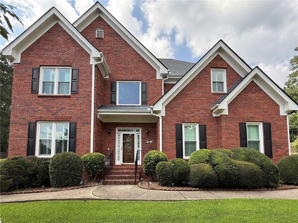 Welcome to 1205 Runnelwood Trail, a stunning 5 bedroom, 4.5 bath brick home located on a quiet cul-de-sac in the highly sought-after Brookwood Estates community. This spacious residence offers nearly 4,000 sq ft of living space with soaring ceilings, hardwood floors, and abundant natural light throughout. The main level features a grand two-story foyer, formal living and dining rooms, and a family room with a cozy fireplace that opens to the gourmet eat-in kitchen with granite counters, large island, breakfast bar, and white cabinetry. The oversized primary suite includes a spa-like bath with dual vanities, soaking tub, separate shower, and bidet. Upstairs bedrooms are generously sized and provide ample closet space. The fully finished terrace level is a true highlight, offering its own kitchen, bedroom, full bath, living area, and private entrance—perfect for in-laws, extended family, or rental opportunities. Outdoor living is equally inviting with a large deck overlooking the landscaped backyard. Additional features include a side-entry two-car garage, built-in bookcases, and two fireplaces. Located in the award-winning Brookwood School Cluster, with easy access to Scenic Highway, The Shoppes at Webb Gin, dining, parks, and commuter routes, this home blends luxury, functionality, and convenience.