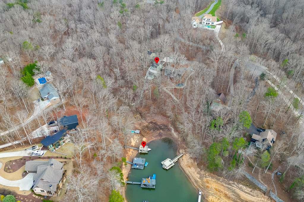 Aerial view of lakefront property at 4008 Donna Drive, Gainesville, GA, showcasing nearby homes, wooded surroundings, and dock area on Lake Lanier.