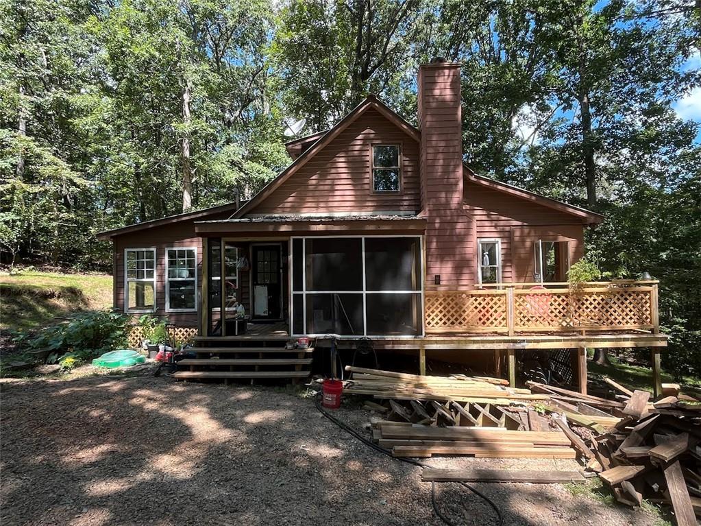 Escape to your own private retreat in the woods! This charming home offers the perfect blend of tranquility and modern comfort, with updated flooring throughout and a stunning stone fireplace that anchors the cozy living space. Enjoy the beauty of every season in the spacious four seasons room, where floor-to-ceiling windows invite natural light and offer serene views of the surrounding forest. Tucked away for seclusion yet conveniently located near Lake Lanier and Don Carter State Park, this property is ideal for nature lovers, outdoor enthusiasts, or anyone seeking peaceful living with easy access to recreation. Don’t miss this rare opportunity!