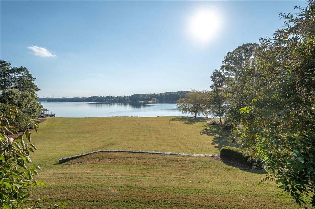 Truly one of the most elegant and refined estates on Lake Lanier is now available for your living and recreational desires. From sunrise to sunset, the day greets you with vast, open views of serenity and enjoyment. Located in the quieter waters in the north end of the lake, this deepwater, level lot of the Chattahoochee Country Club area resonates with staycation. The main floor has everything you need for everyday living to include a separate office space and study should you need to work for home, while still affording additional elbow room in the upper level and terrace level for those days we are all too familiar with when family and friends come for extended visits. And should you need additional space to grow or get away, there's even unfinished space over the garage for a workroom or additional bedroom. Multiple outdoor entertaining areas, in addition to a large yard just calling for a pool, expands your living spaces to enjoy the lake and all it brings to make life just a little bit sweeter.
