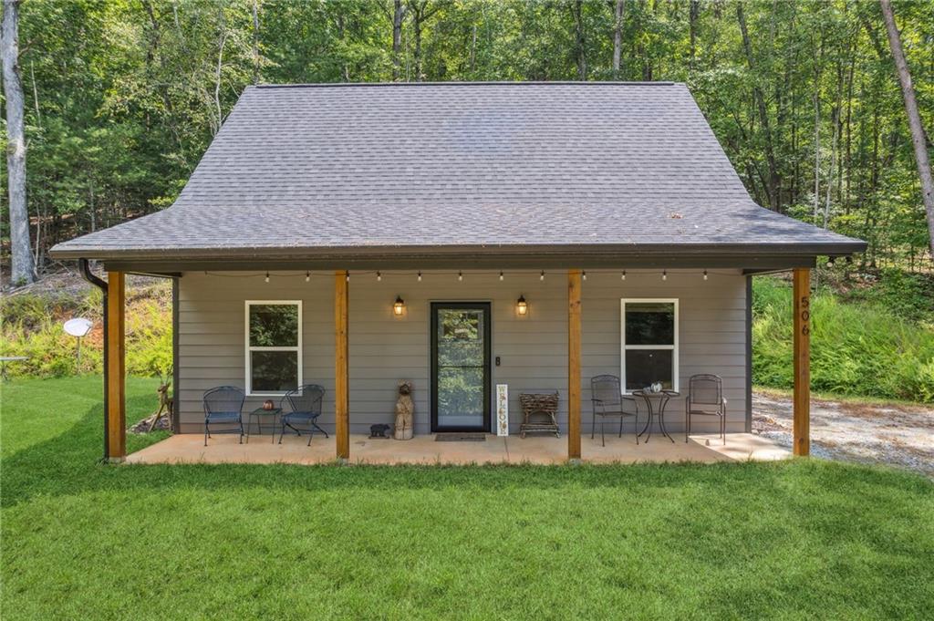 Escape from the hustle and bustle of the city to your own North GA Mountains retreat. Very private 3 acres with 185' river frontage on the beautiful Chestatee River. Enjoy watching the wildlife from your covered front porch while you have your morning coffee. Relax listening to the sounds of nature, sip wine and listen to the shoals on the deck at the river, swim, float, & fish for trout. Roast marshmellows & make s'mores on the outdoor fire pit. Beautiful open floor plan Home has luxury vinyl plank throughout. 2 bedrooms, 1 bath with walk in shower. Main bedroom has huge walk in closet. Kitchen has stained cabinets, granite countertops and built in wine rack. Laundry/mudroom with outdoor entrance. Fireplace in living room with gas logs. Home is wired for a generator. Outdoor 18x26 metal storage building can be used as a garage/workshop. Property already has well and septic installed waiting for you to build your dream home fronting the Chestatee River. Hard to find gently sloping lot to build on and secluded from the cottage. Perfect set up for a great vacation rental, full time rental or live in the cottage while you build your dream home. Only 15 minutes to Historic Dahlonega Square with shopping and restaurants. Minutes to Frogtown, 3 Sisters, Kaya Wineries and Big Creek Distillery. Convenient to several more wineries and all that North GA has to offer. No HOA or restrictions. Low clearance cars not recommended on gravel road. All contents are included. Don't miss out on this amazing property!