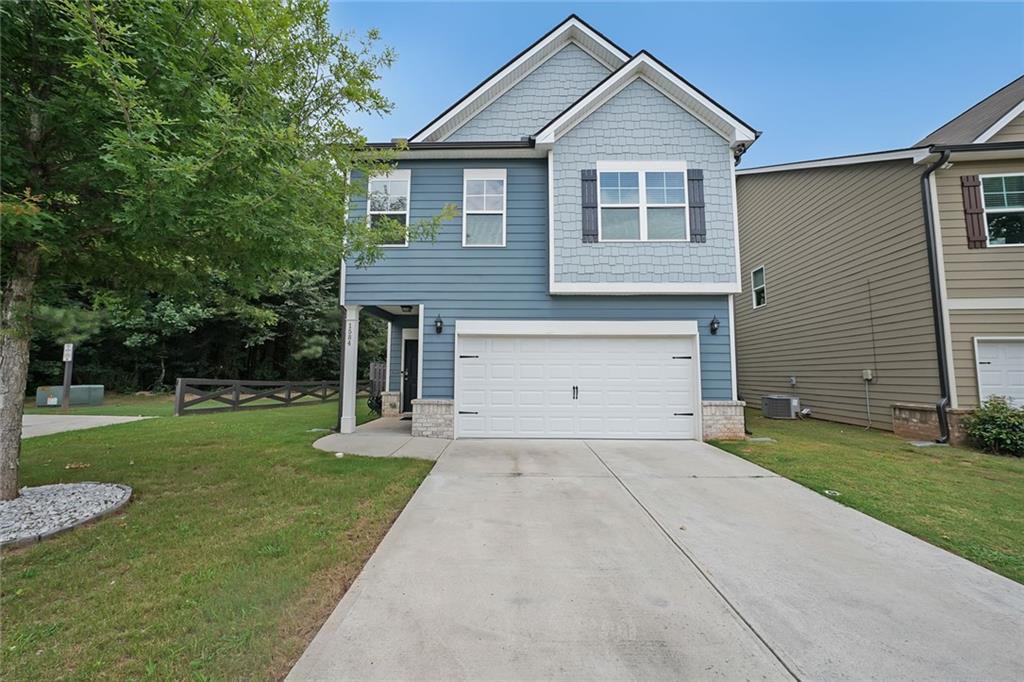 This beautifully maintained home sits on a desirable corner lot and features a two-car garage equipped with an EV charging station. Ideally located near golf courses, Georgia State campus, and Stone Mountain Park for endless outdoor recreation. Enjoy easy access to shopping, dining, and I-285 for a smooth commute. Inside, the open-concept floor plan welcomes you with hardwood floors and a warm, inviting atmosphere. The family room is anchored by a classic fireplace, flanked by floating shelves and built-in storage. The adjoining kitchen and dining area boast granite countertops, a large island with breakfast bar, subway tile backsplash, stainless steel appliances, and ample counter space, perfect for prep, serving, and entertaining. Step outside through the dining area to a covered back patio, offering a seamless flow for indoor-outdoor living. A convenient half bath completes the main level. Upstairs, a versatile flex space provides the ideal spot for a reading nook, home office, playroom, or lounge. The oversized primary suite features a double vanity, soaking tub, and a walk-in shower. Three additional bedrooms are generously sized, and two full bathrooms offer plenty of space for family or guests. Outside, the home features both an invisible fence and privacy fencing for peace of mind. The wooded views and a protected creek behind the property create a serene, natural backdrop. Whether you're enjoying quiet evenings on the covered patio or entertaining guests, this home checks all the boxes for comfort, style, and location.